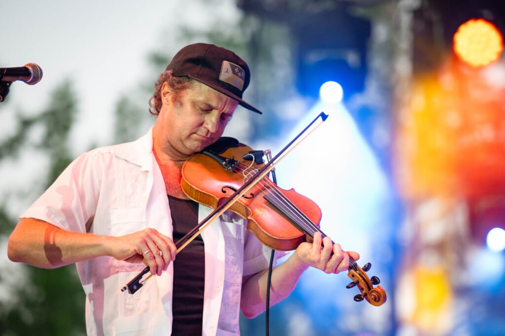 Louis Michot playing the violin on stage with lights blurred behind him at 2025 Lafayette Festival International 1654