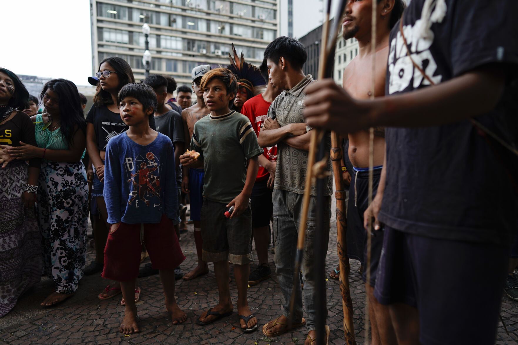 <p>FILE - In this March 27, 2018, file photo, Indigenous people stand outside Sao Paulo's City Hall during a demonstration. On Friday, Oct. 22, The Associated Press reported on stories circulating online incorrectly asserting that a video showed aboriginal people in Australia defending themselves with bows and arrows against authorities trying to forcibly administer COVID-19 vaccines. In fact, the video showed a group of Guarani Indigenous people in Sao Paulo, Brazil, demonstrating against health care policy changes in March 2019. (AP Photo/Victor R. Caivano)</p>