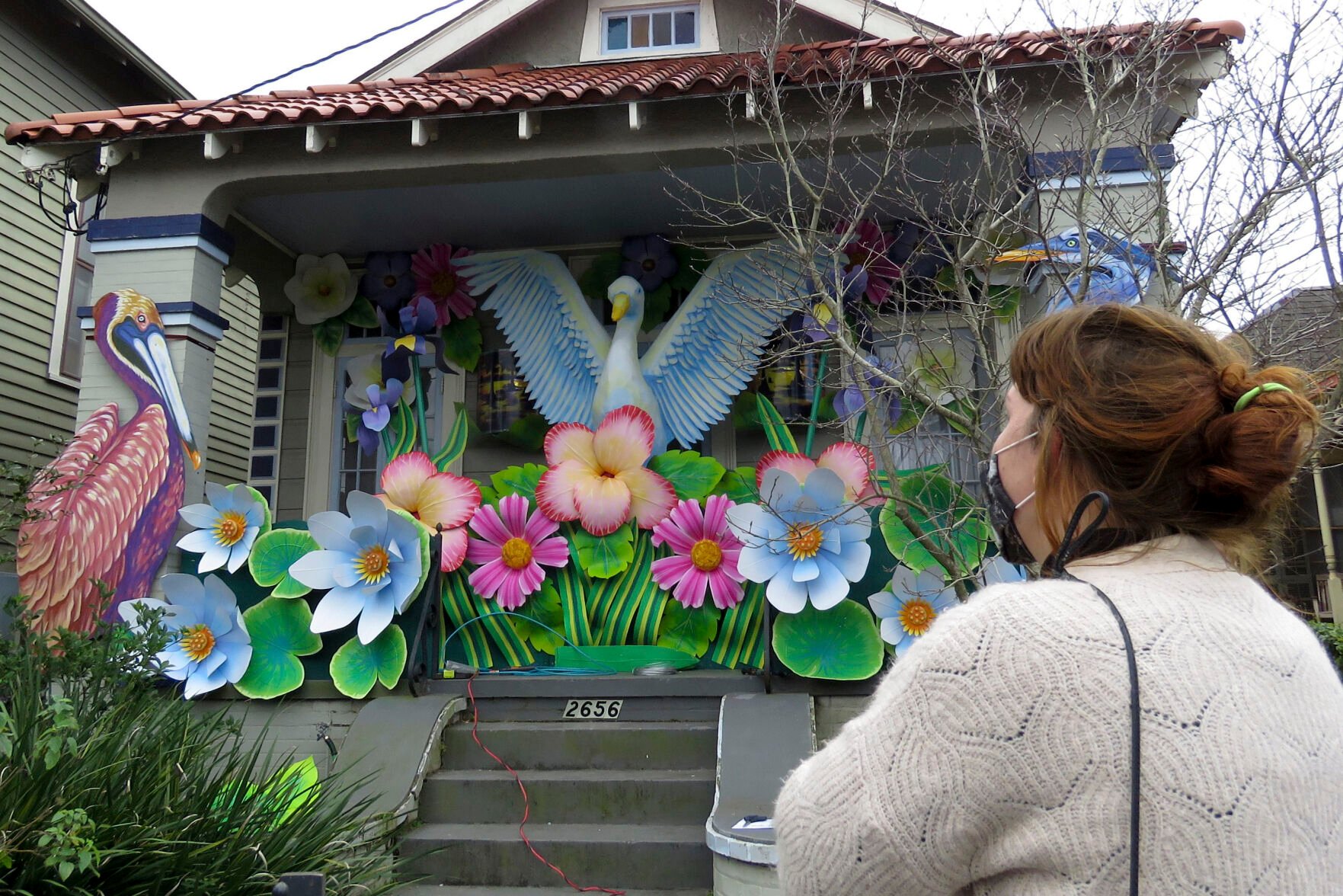 <p>FILE - In this Friday, Jan. 8, 2021, file photo, designer Caroline Thomas looks at a house decorated like a parade float in New Orleans, as all around the city, thousands of houses are being decorated as floats because the coronavirus pandemic has canceled parades that usually take place on Mardi Gras. The group behind the wave of houses decorated to look like floats during the pandemic-curtailed Mardi Gras is continuing the tradition in 2022 while the mayor weighs whether to allow parades during the upcoming Carnival season. (AP Photo/Janet McConnaughey, File)</p>