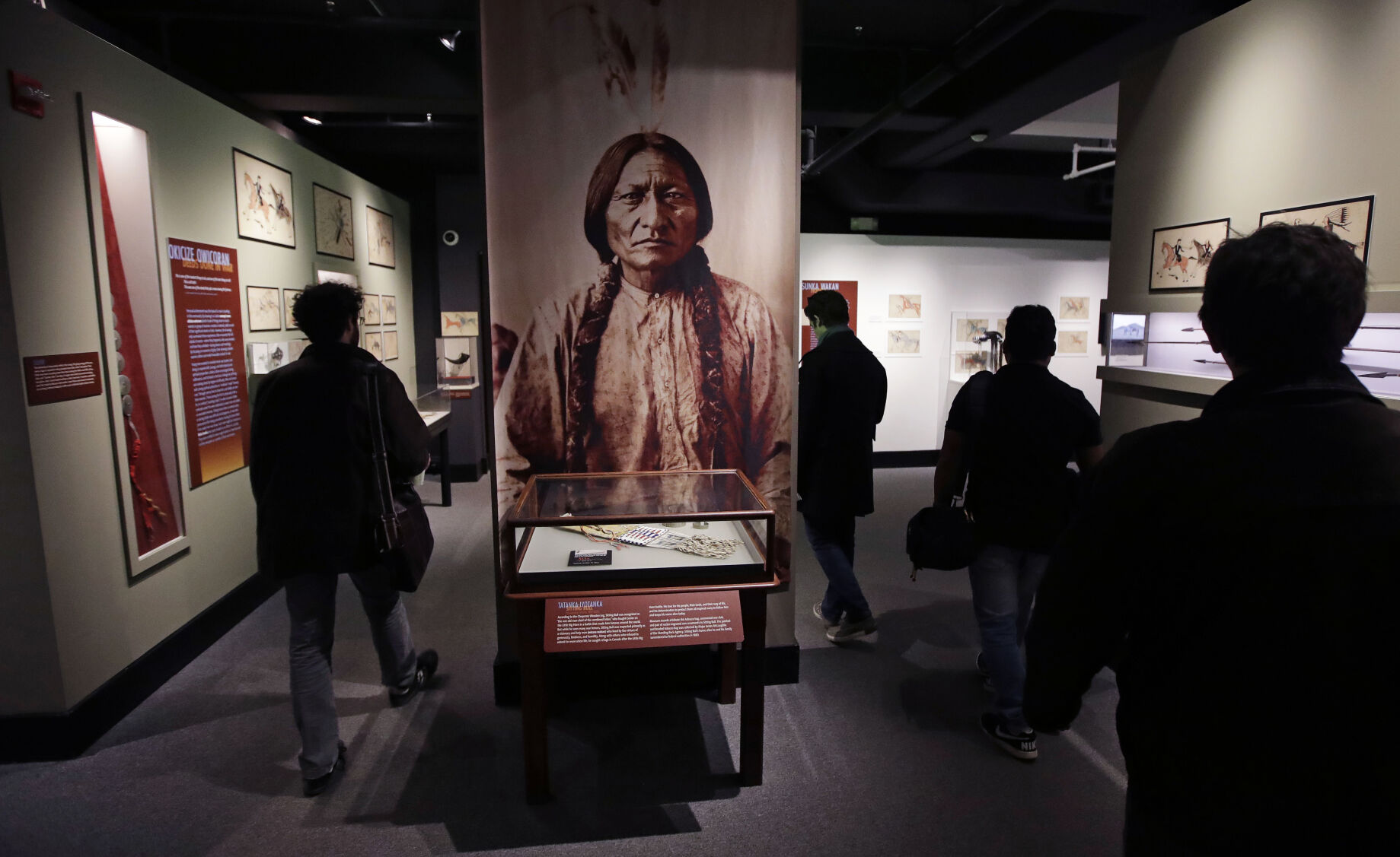 <p>Patrons pass a portrait featuring Sitting Bull, part of the Hall of North American Indian exhibit, at the Peabody Museum of Archaeology & Ethnology at Harvard University in Cambridge, Mass., Thursday, Oct. 13, 2016. </p>
