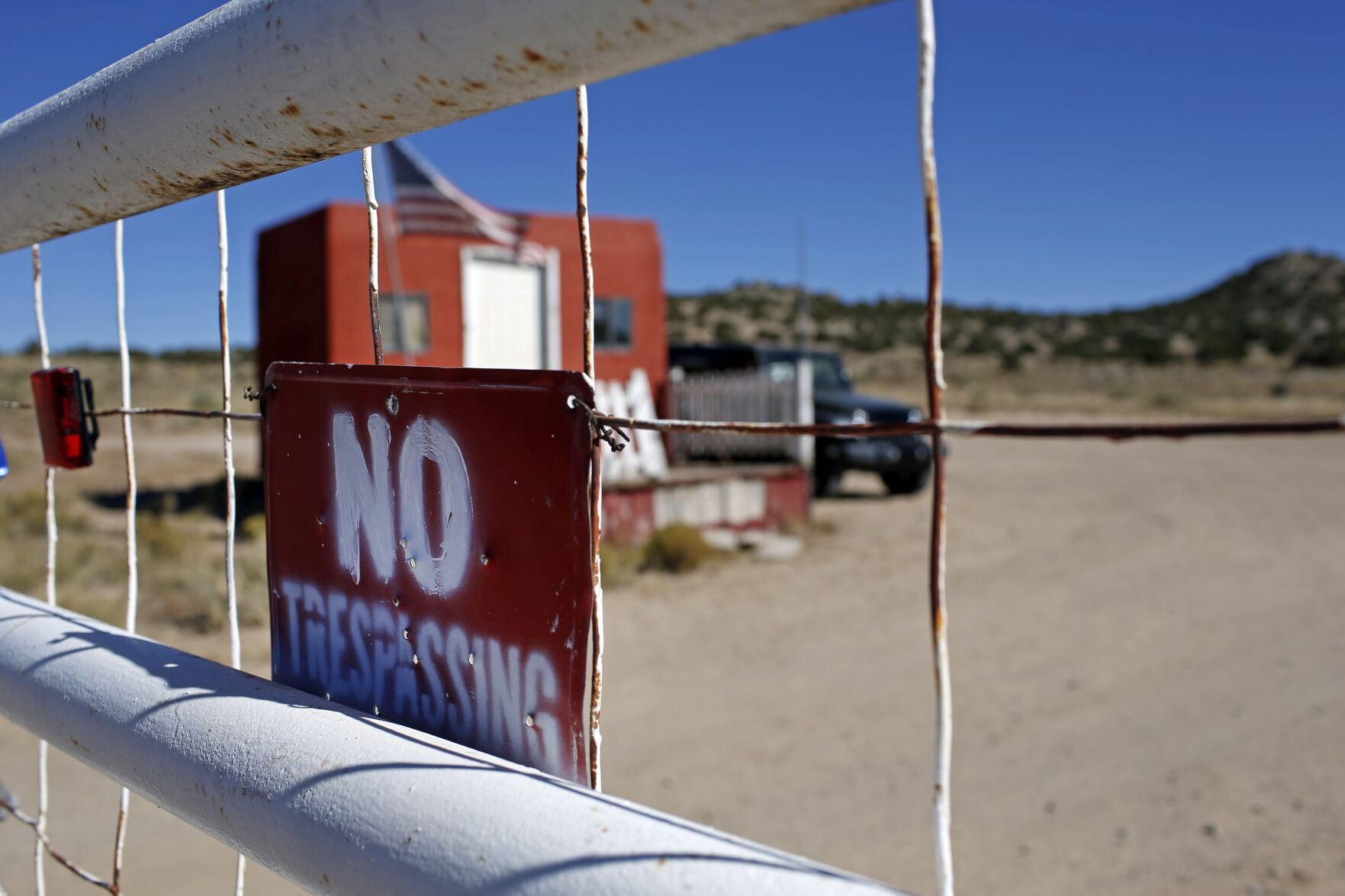 <p>A "No Trespassing" sign hangs on the fence at the entrance to the Bonanza Creek Ranch film set in Santa Fe, N.M., Wednesday, Oct. 27, 2021. New Mexico authorities said they have recovered a lead projectile believed to have been fired from the gun used in the fatal movie-set shooting. (AP Photo/Andres Leighton)</p>