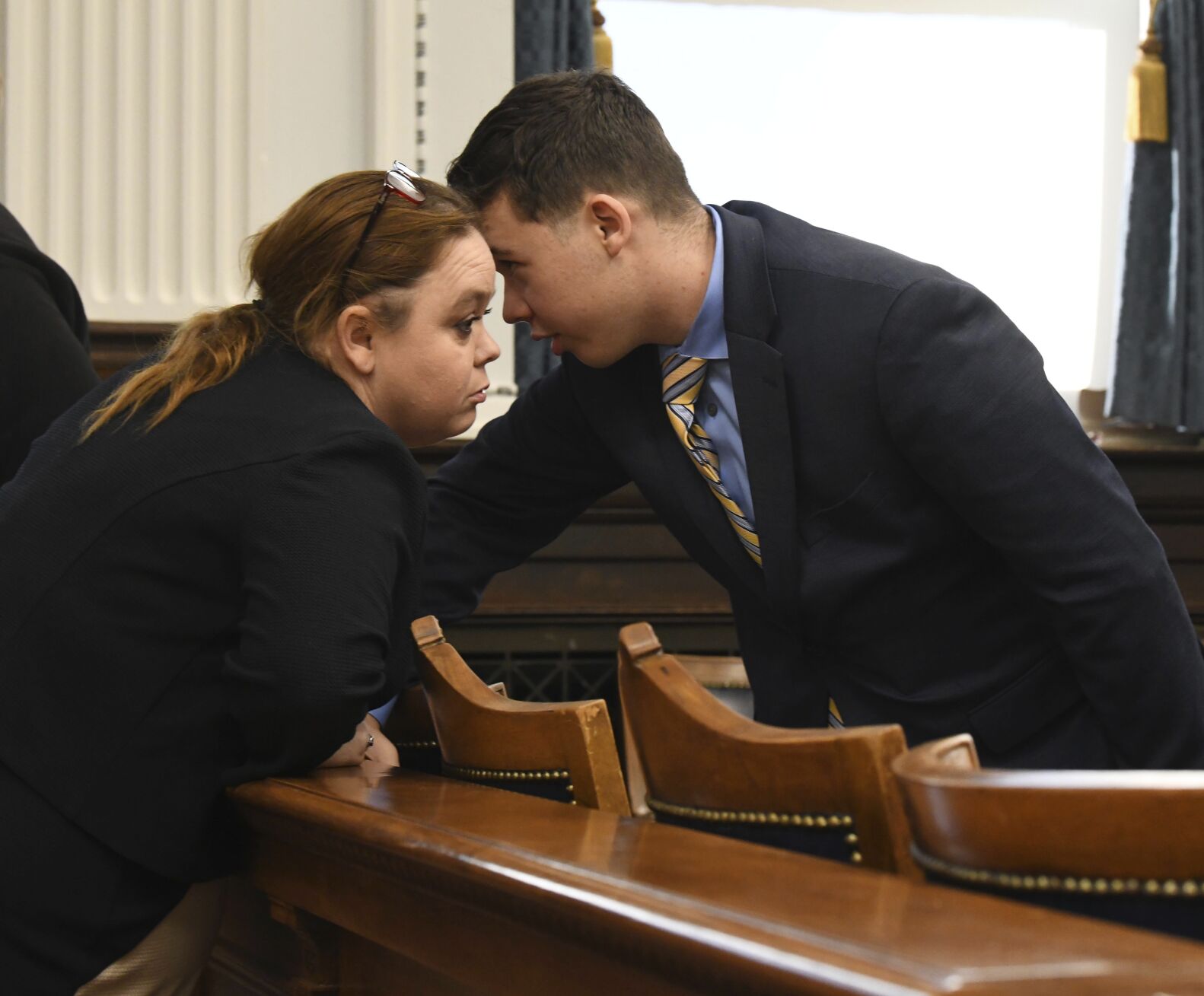 <p>FILE - Wendy Rittenhouse, left, talks to her son Kyle Rittenhouse before the start of his trial at the Kenosha County Courthouse in Kenosha, Wisconsin, on Wednesday, Nov. 3, 2021. On Friday, Nov. 19, 2021, The Associated Press reported on stories circulating online incorrectly claiming that Wendy Rittenhouse drove her son across state lines and dropped him off at the protest in Kenosha, Wisconsin, on the night he shot three people in August 2020. (Mark Hertzberg/Pool Photo via AP, File)</p>