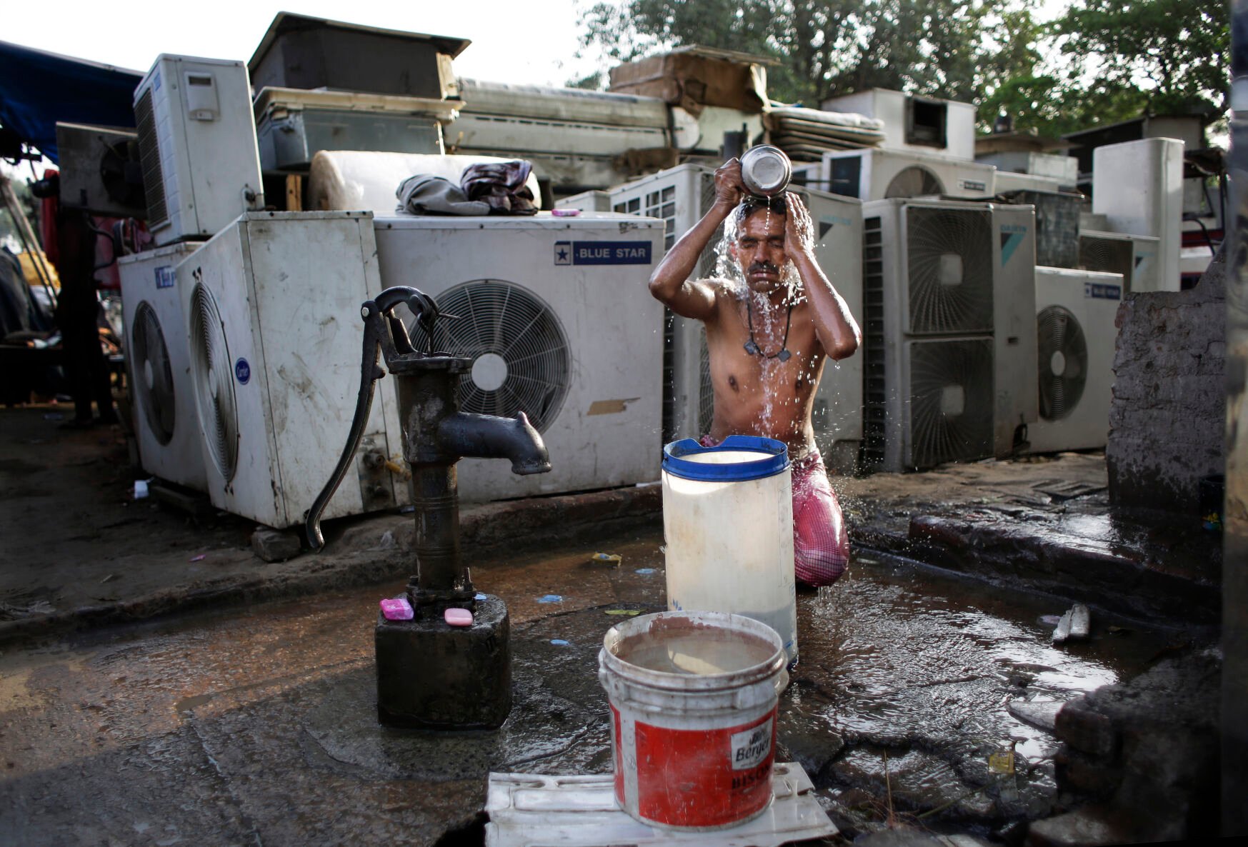 <p>A migrant daily wage worker bathes at a public well pump on a hot morning in New Delhi, India, on May 17, 2016. Scorching summer temperatures, hovering well over 104 degrees Fahrenheit, are making life extremely tough for millions of poor across north India. Without access to air conditioning and sometimes even an electric fan, they struggle to cope with the heat in their inadequate homes.</p>