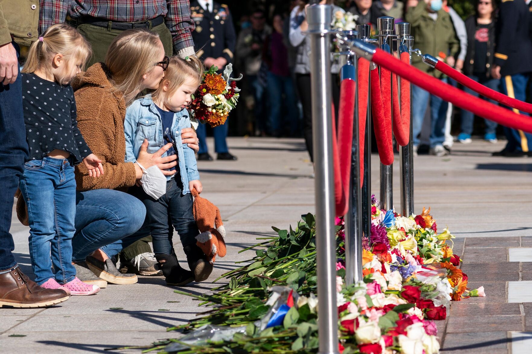 <p>Stacy Wittmeyer, center, kisses her daughter Margaux Wittmeyer, 2, right, both from Springfield, Virginia, after placing a flower during a centennial commemoration event at the Tomb of the Unknown Soldier in Arlington National Cemetery on Tuesday in Arlington, Virginia.</p>