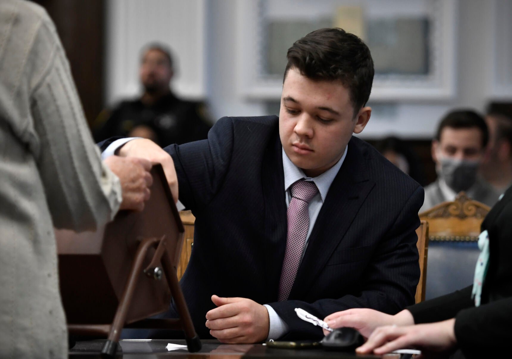 <p>FILE - Kyle Rittenhouse pulls numbers of jurors out of a tumbler during his trial at the Kenosha County Courthouse in Kenosha, Wis., on Nov. 16, 2021. </p>