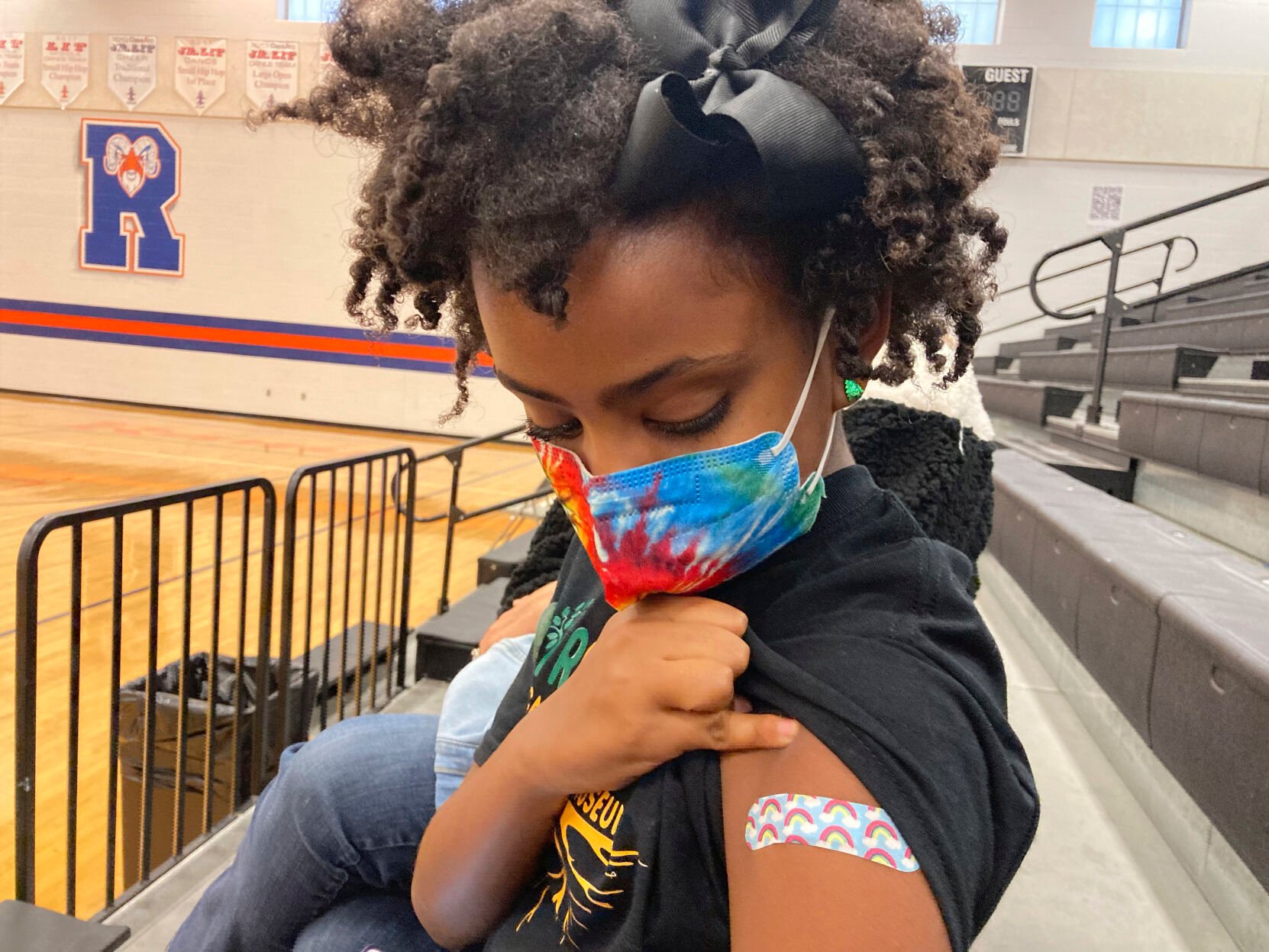 <p>Solome Walker, 9, looks down at her bandage after getting her first Pfizer COVID-19 shot at a vaccination clinic for young students at Ramsey Middle School in Louisville, Ky., on Nov. 13, 2021.</p>
