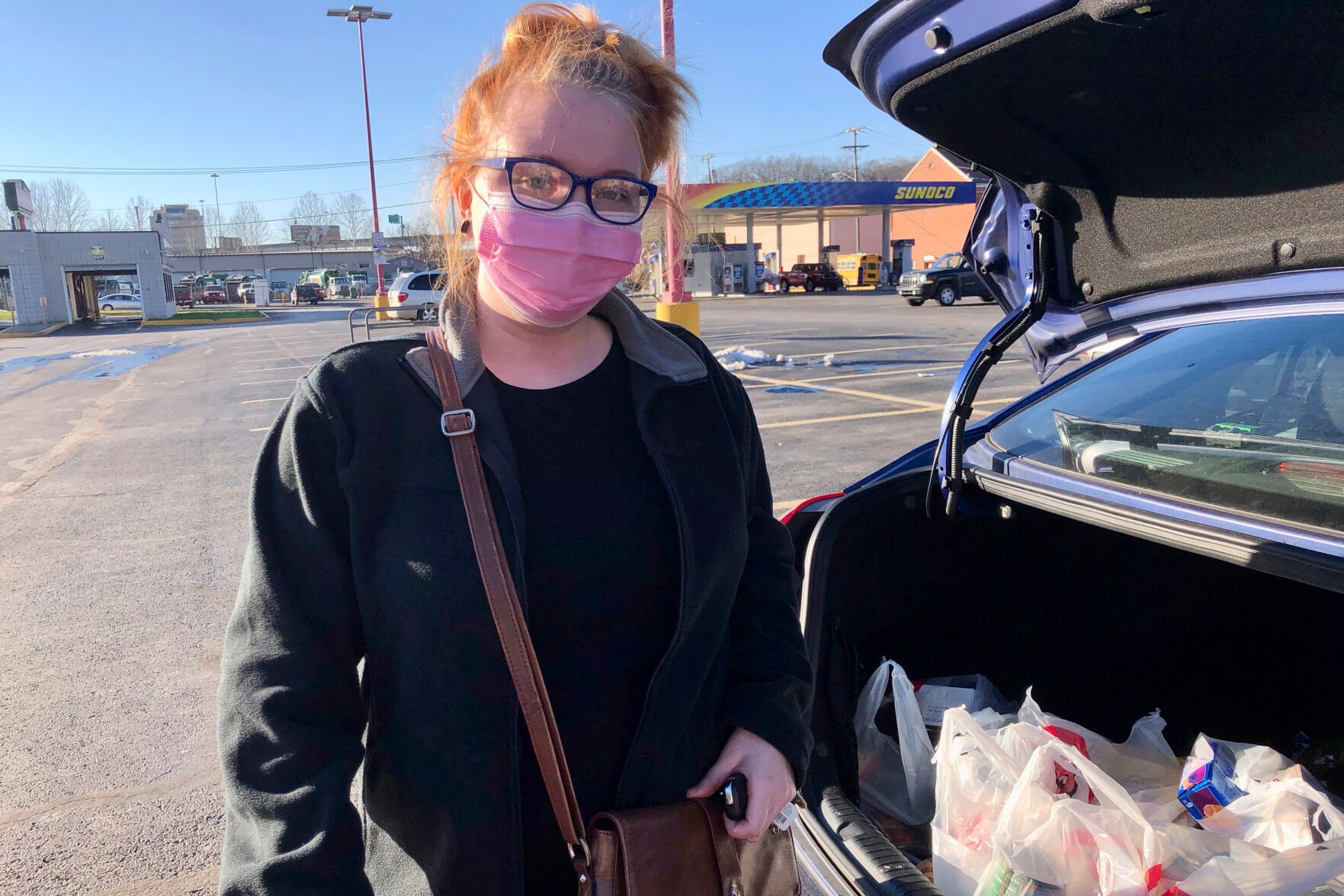 <p>Hairdresser Chelsea Woody stands outside her car at a grocery store Tuesday, Jan. 11, 2022, in Charleston, W.Va. </p>