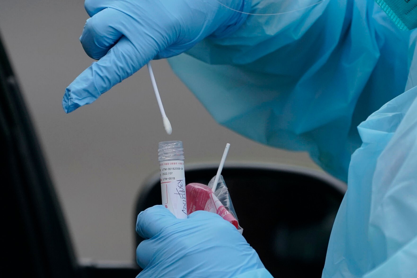 <p>FILE - A worker at a drive-up COVID-19 testing clinic puts a nose swab into a tube of liquid, Tuesday, Jan. 4, 2022, in Puyallup, Wash., south of Seattle. On Friday, Jan. 7, 2022, The Associated Press reported on stories circulating online incorrectly claiming a photo showing a COVID-19 test kit that includes swabs labeled “positive” and “negative” proves tests are manipulated to give a predetermined result. (AP Photo/Ted S. Warren)</p>