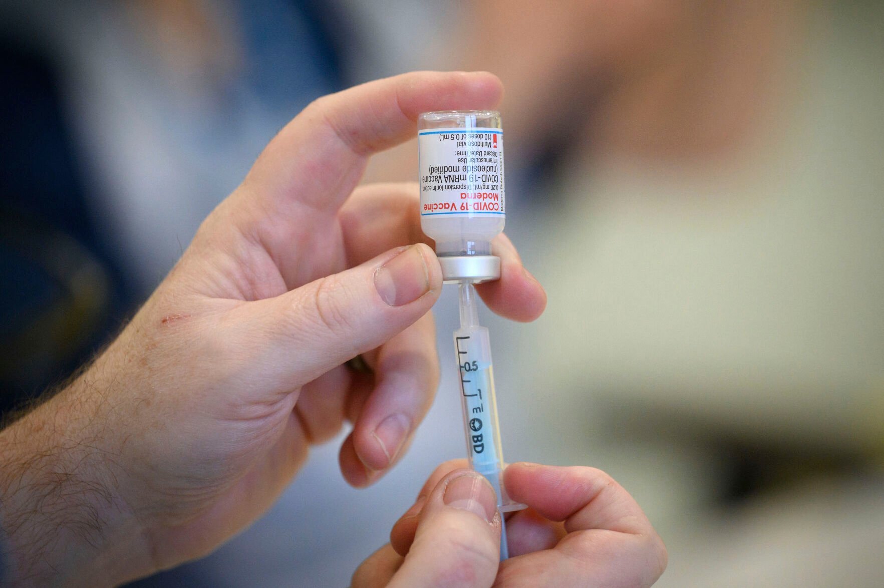 <p>FILE - Medical staff and volunteers prepare shots of the COVID-19 vaccine a vaccination center in Ramsgate, England, Thursday, Dec. 16, 2021. On Friday, Jan. 21, The Associated Press reported on stories circulating online incorrectly claiming a photo of a poster distributed by the National Health Service in England warning that COVID-19 vaccines cause Bell’s palsy.(Leon Neal, Pool via AP)</p>