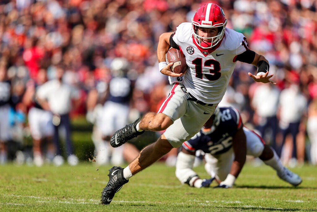 <p>FILE - Georgia quarterback Stetson Bennett (13) carries the ball against Auburn during the first half of an NCAA college football game Saturday, Oct. 9, 2021, in Auburn, Ala. Georgia plays Alabama in the College Football Playoff national championship game on Jan. 10, 2022. (AP Photo/Butch Dill)</p>