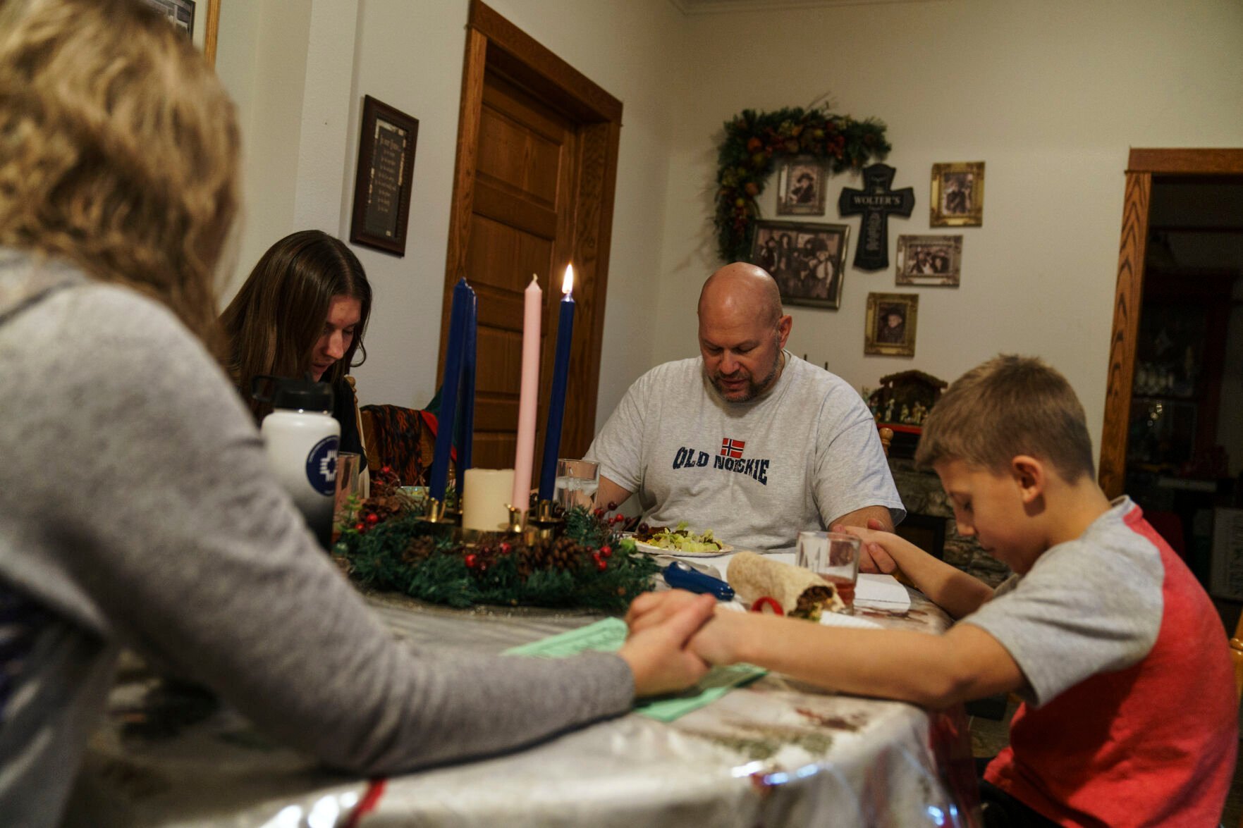 <p>Jason Wolter, rear, prays at the dinner table with his wife, Tracy, from left, daughter, Bella, 17, and son, Zeb, 9, at their home in Benson, Minn., Monday, Nov. 29, 2021. Wolter knows that plenty of people would write him off as just another conspiracy monger. He also worries his conservative opinions color what he believes. </p>