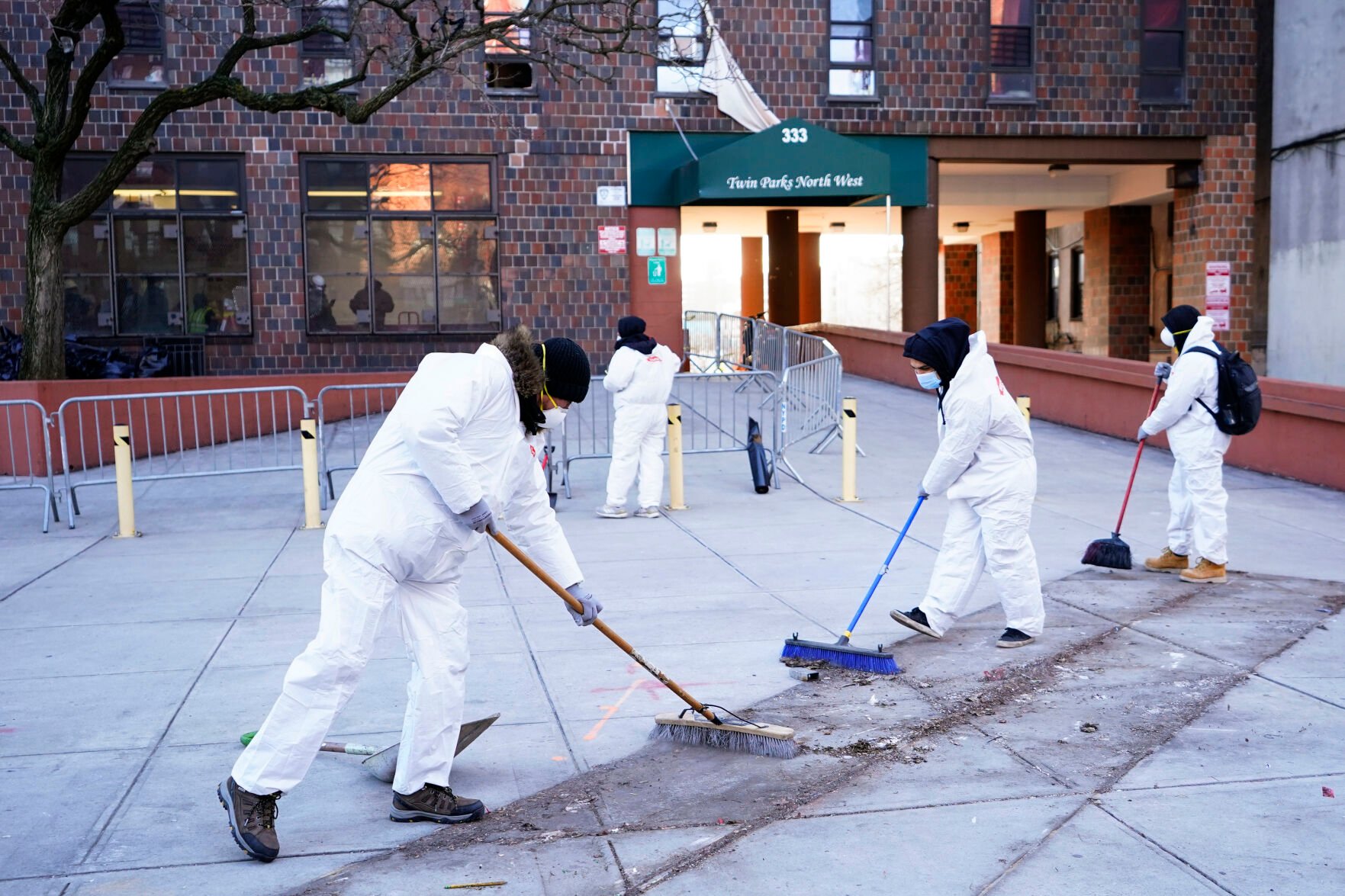 <p>Workers in protective clothing sweep outside apartment building which suffered the city's deadliest fire in three decades, in the Bronx borough of New York, Tuesday, Jan. 11, 2022. </p>