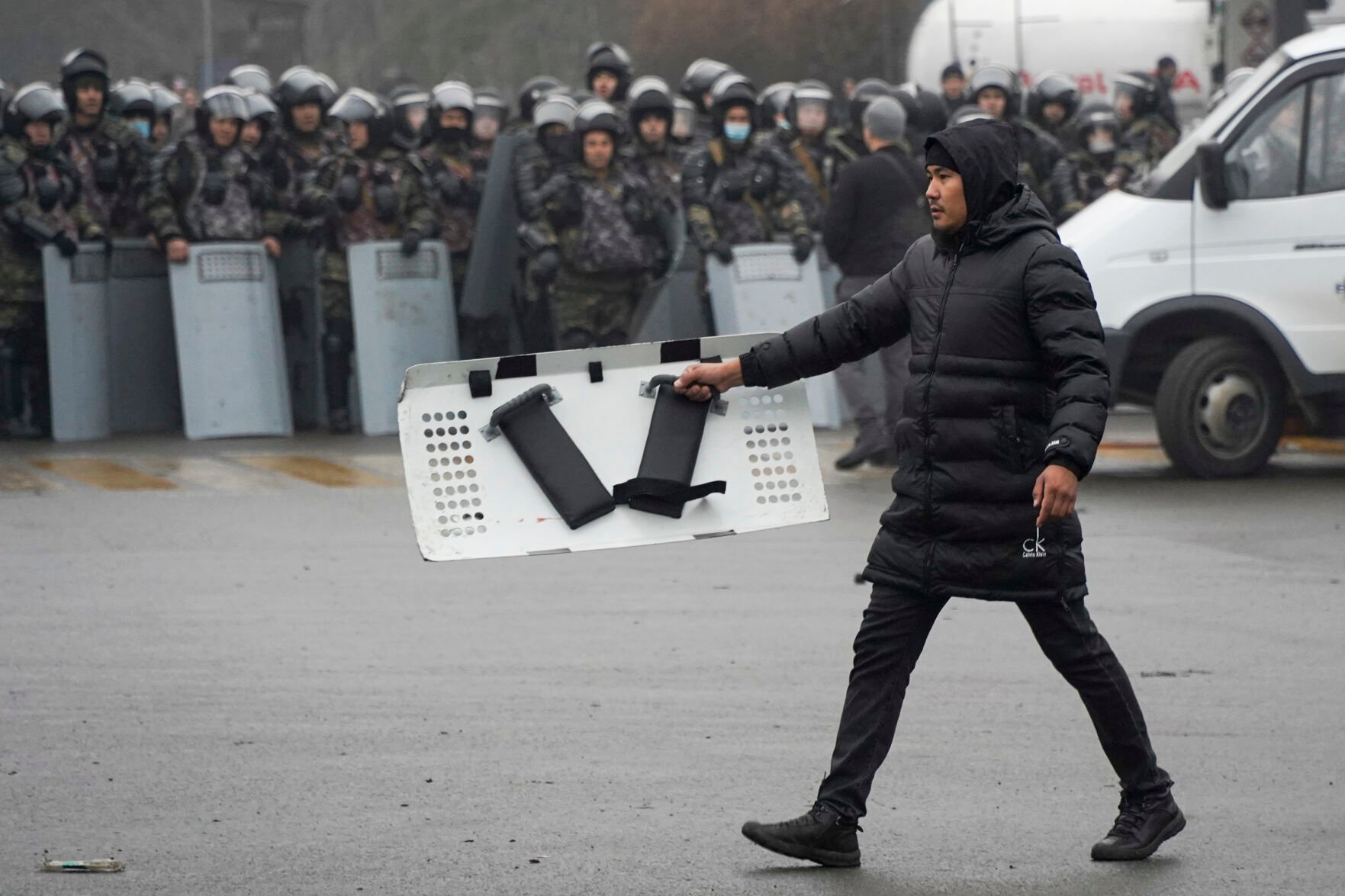 <p>A demonstrator carries a police shield in front of police line during a protest in Almaty, Kazakhstan, Wednesday, Jan. 5, 2022. Demonstrators protesting rising fuel prices broke into the mayor's office in Kazakhstan's largest city Wednesday and flames were seen coming from inside, according to local news reports. Many of the demonstrators who converged on the building in Almaty carried clubs and shields, the Kazakh news site Zakon said.</p>