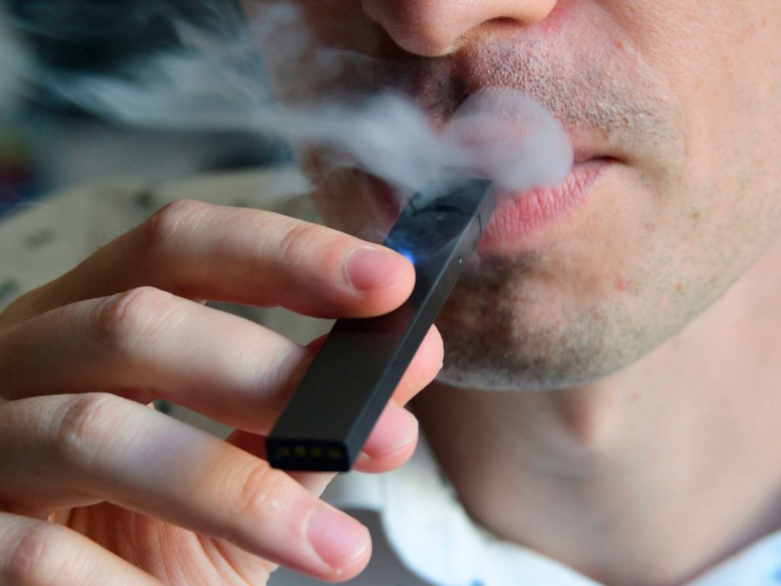 <p>An illustration shows a man exhaling smoke from an electronic cigarette in October 2018.</p>