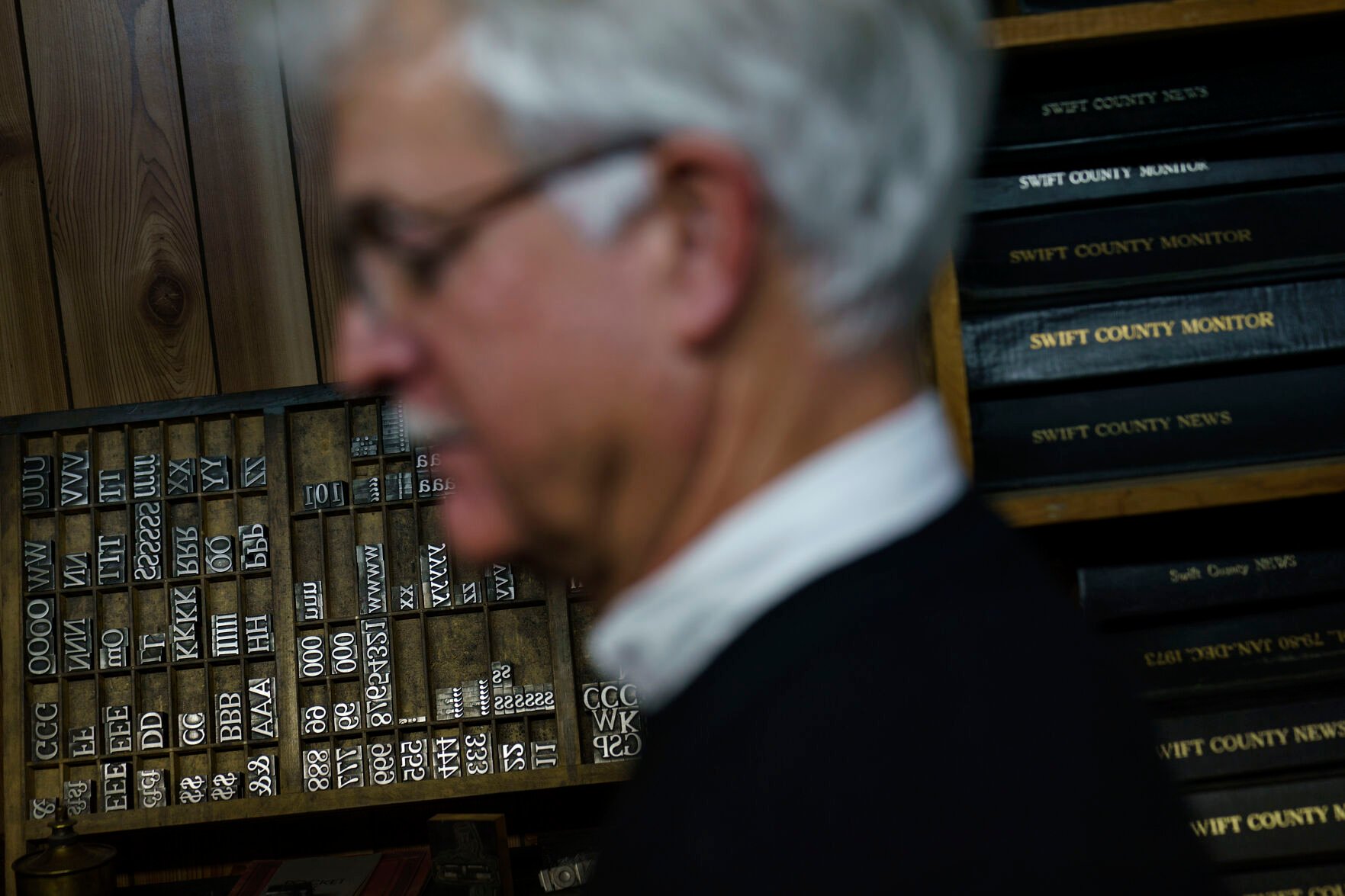 <p>Reed Anfinson, publisher of the weekly newspaper, The Swift County Monitor-News, walks by old printing press block letters and past editions at the paper's office in Benson, Minn., Monday, Nov. 29, 2021. Most weeks Anfinson, the publisher, editor, photographer and reporter, writes every story on the paper's front page. </p>