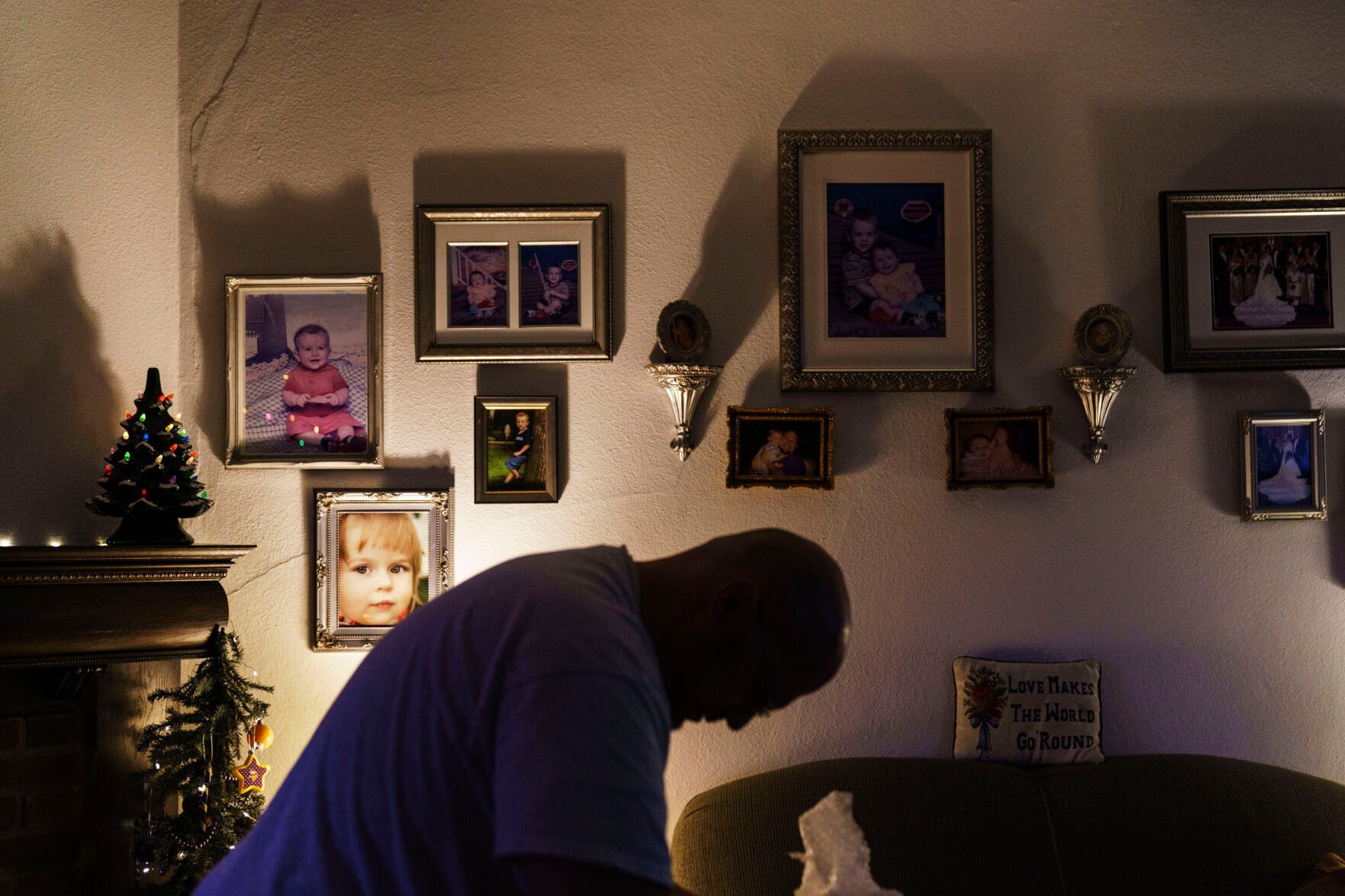 <p>Family photos hang on the wall as Jason Wolter puts up Christmas decorations at his home in Benson, Minn., Monday, Nov. 29, 2021. Wolter, whose home library includes everything from Sophocles to "The Grapes of Wrath," is a careful reader, in his own way. </p>