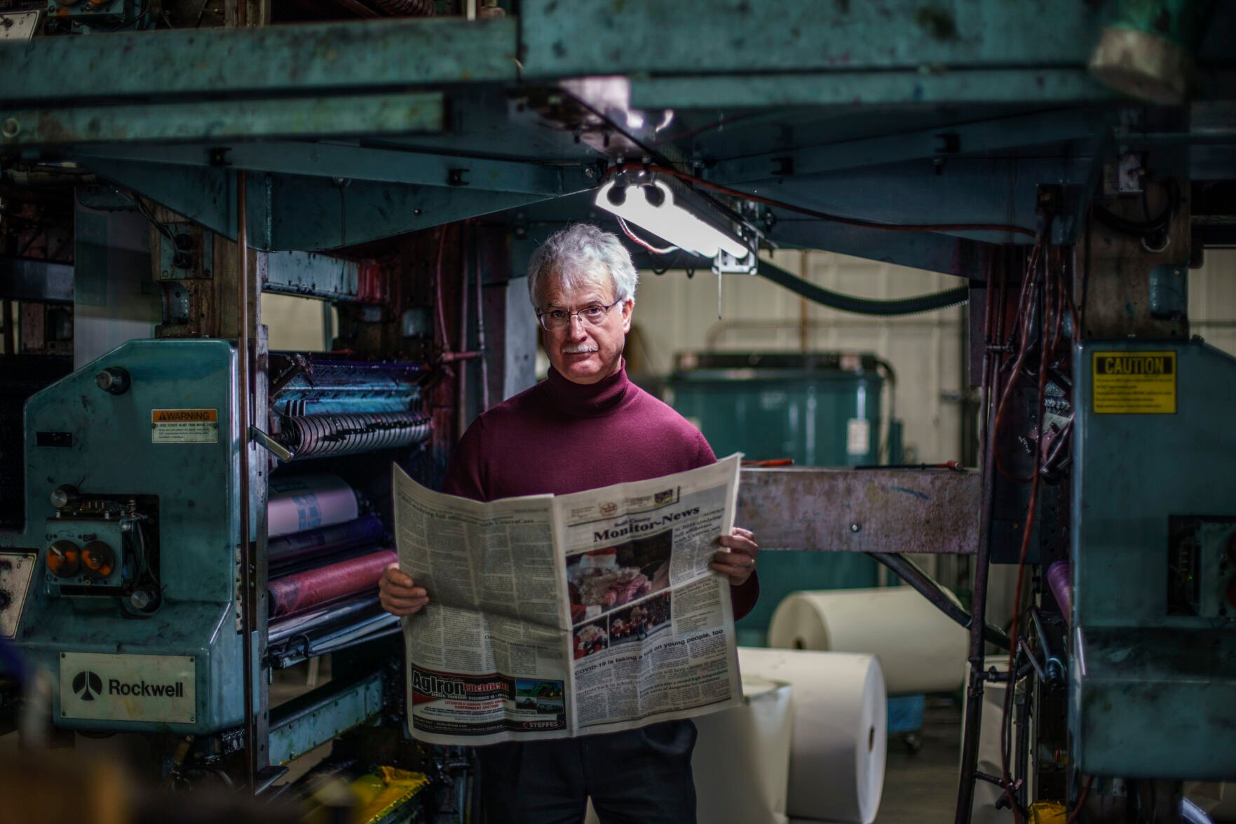 <p>Reed Anfinson, publisher of The Swift County Monitor-News, holds the latest edition as he stands for a portrait at Quinco Press in Lowry, Minn., Tuesday, Nov. 30, 2021. Anfinson's weekly column is a local lightning rod. He says it's his duty to expose people to new ideas, even unpopular ideas like stricter gun control. </p>