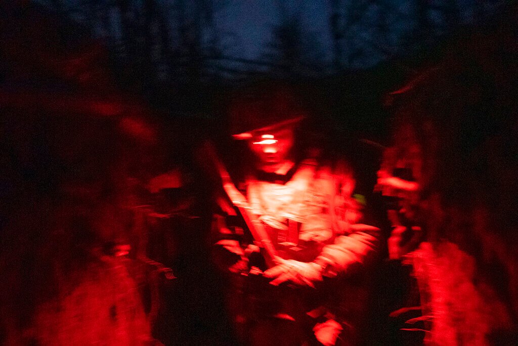 <p>FILE - A Ukrainian serviceman walks along a trench on a position at the line of separation between Ukraine-held territory and rebel-held territory near Zolote, Ukraine, late Feb. 19, 2022. </p>