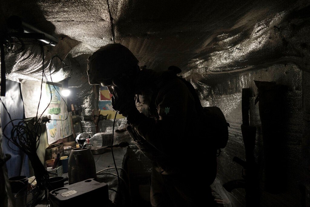 <p>Zakhar Leshchyshyn, a Ukrainian serviceman, reports to a commander via military intercom while in a shelter at the frontline positions near Zolote, Ukraine, Saturday, Feb. 19, 2022. </p>