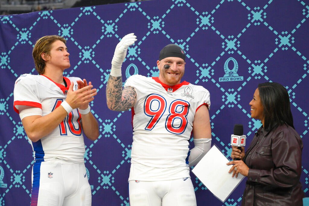 <p>AFC quarterback Justin Herbert, left, of the Los Angeles Chargers, reacts with AFC defensive end Maxx Crosby (98), of the Las Vegas Raiders, after they were named the offensive and defensive MVPs in the Pro Bowl NFL football game against the NFC, Sunday, Feb. 6, 2022, in Las Vegas. (AP Photo/David Becker)</p>