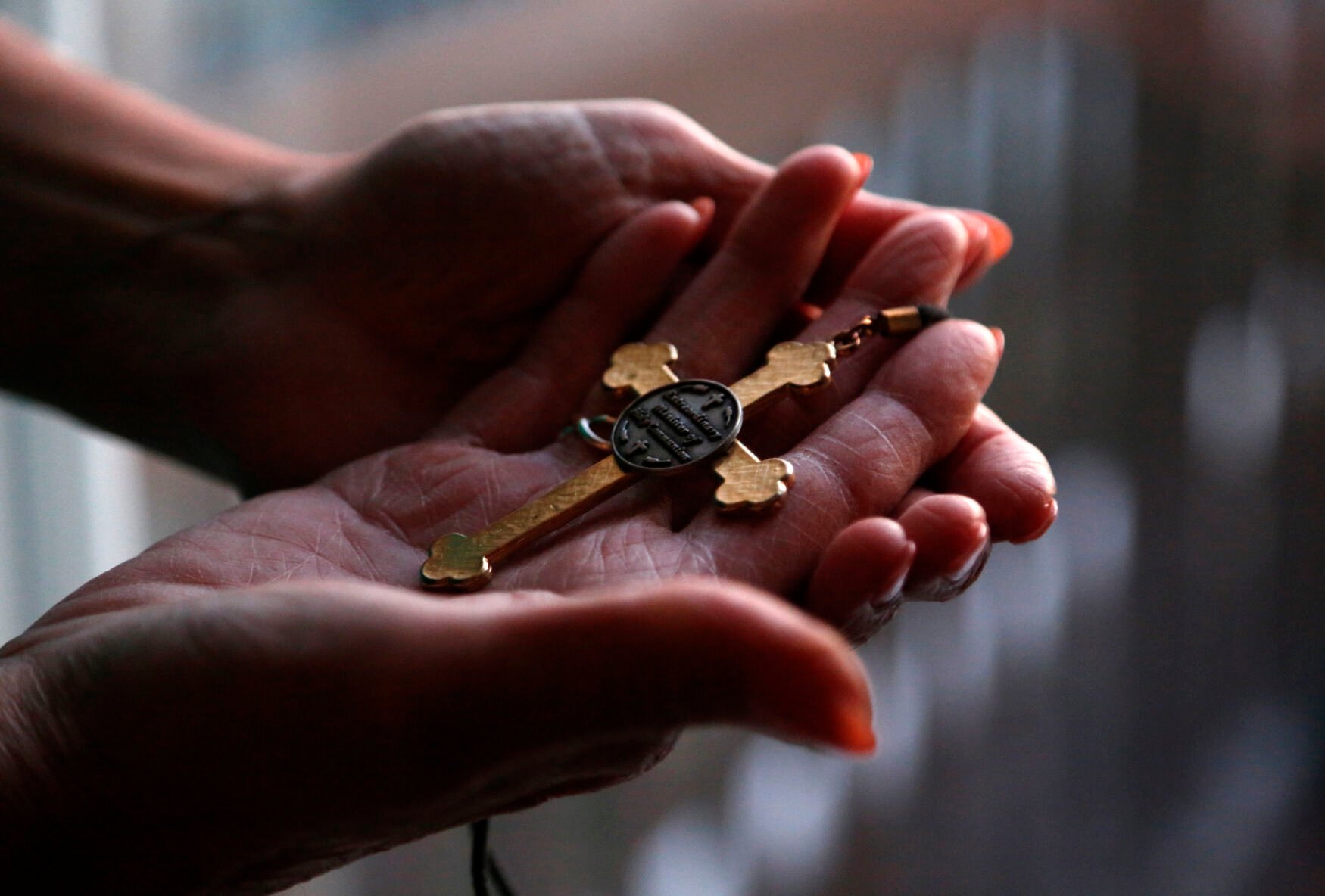 <p>Christine Zuba holds the cross she wears when serving as a eucharistic minister at Saints Peter and Paul Catholic Church at her home in Blackwood, New Jersey, on Monday, Feb. 14, 2022. After coming out as transgender at age 58, Zuba, a lifelong Catholic, was welcomed into the parish. </p>