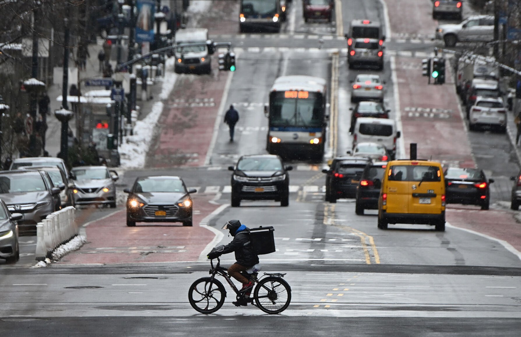 <p>A man on a delivery bike rides in the street after a winter storm hit New York City, on February 19, 2021.</p>