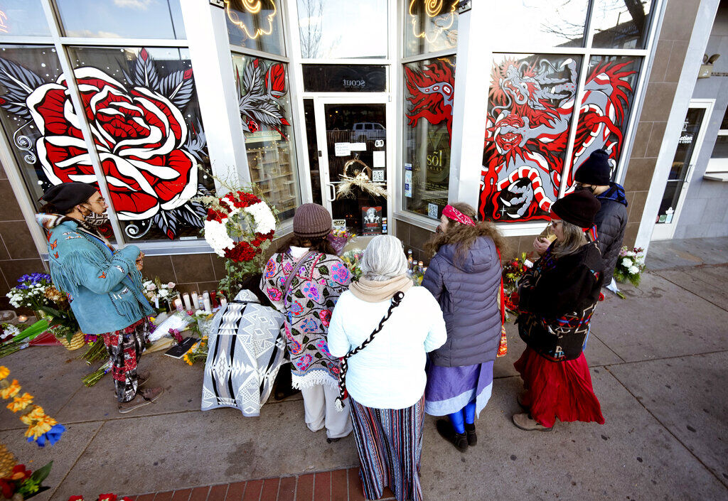 <p>FILE - Mourners gather outside a tattoo parlor, one of the scenes of a shooting spree by Lyndon McCleod, in Denver on on Dec. 28, 2021. </p>