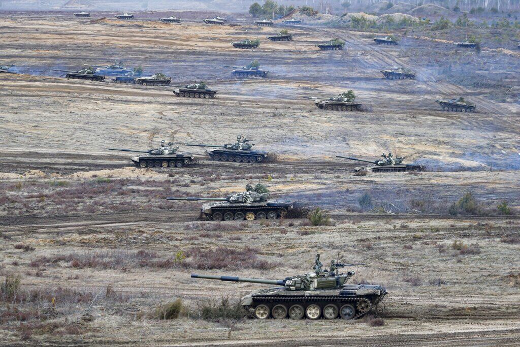 <p>FILE - Tanks move during the Union Courage-2022 Russia-Belarus military drills at the Obuz-Lesnovsky training ground in Belarus, Feb. 19, 2022. Over the past year, Russia alternately added and subtracted troops along the border. </p>