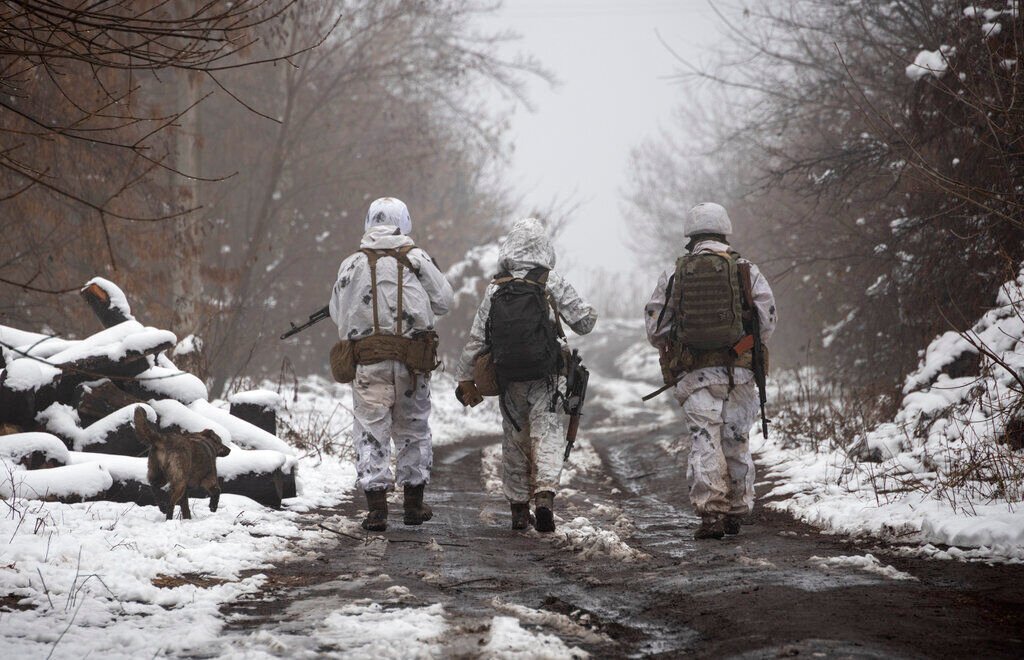<p>FILE - Ukrainian soldiers walk at the line of separation from pro-Russian rebels near Katerinivka, Donetsk region, Ukraine, Tuesday, Dec 7, 2021. </p>