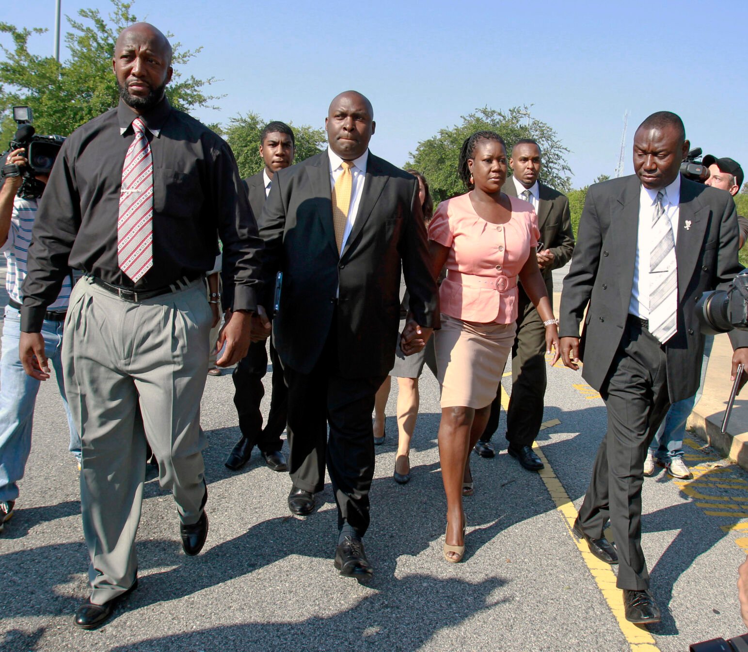 <p>FILE - Tracy Martin, left, father of Trayvon Martin, Jahvaris Fulton, second from left back, brother of Trayvon Martin, attorney Daryl Parks, center, Sybrina Fulton, mother of Trayvon Martin and attorney Benjamin Crump, right, arrive at the Seminole County Criminal Justice Center to attend a bond hearing for George Zimmerman, on June 29, 2012, in Sanford, Fla. The killing of Trayvon Martin at the hands of a stranger still reverberates 10 years later -- in protest, in partisanship, in racial reckoning and reactionary response, in social justice and social media. (AP Photo/John Raoux, File)</p>