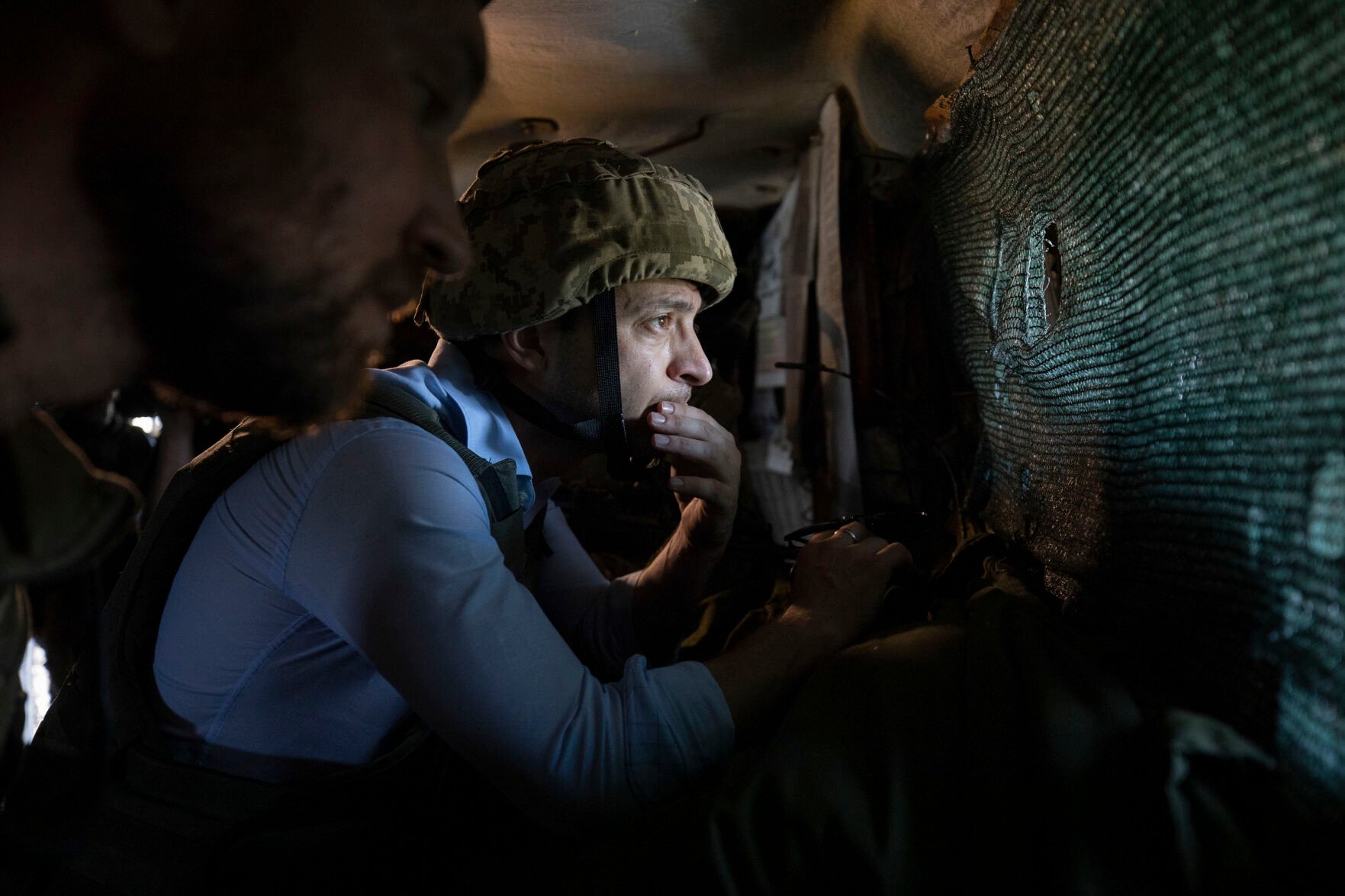 <p>FILE - In this undated file photo provided by the Ukrainian Presidential Press Office, President Volodymyr Zelenskyy looks at a front-line position from a shelter as he visits eastern Ukraine, where the country's military has been locked in a conflict with Russia-backed separatists. </p>