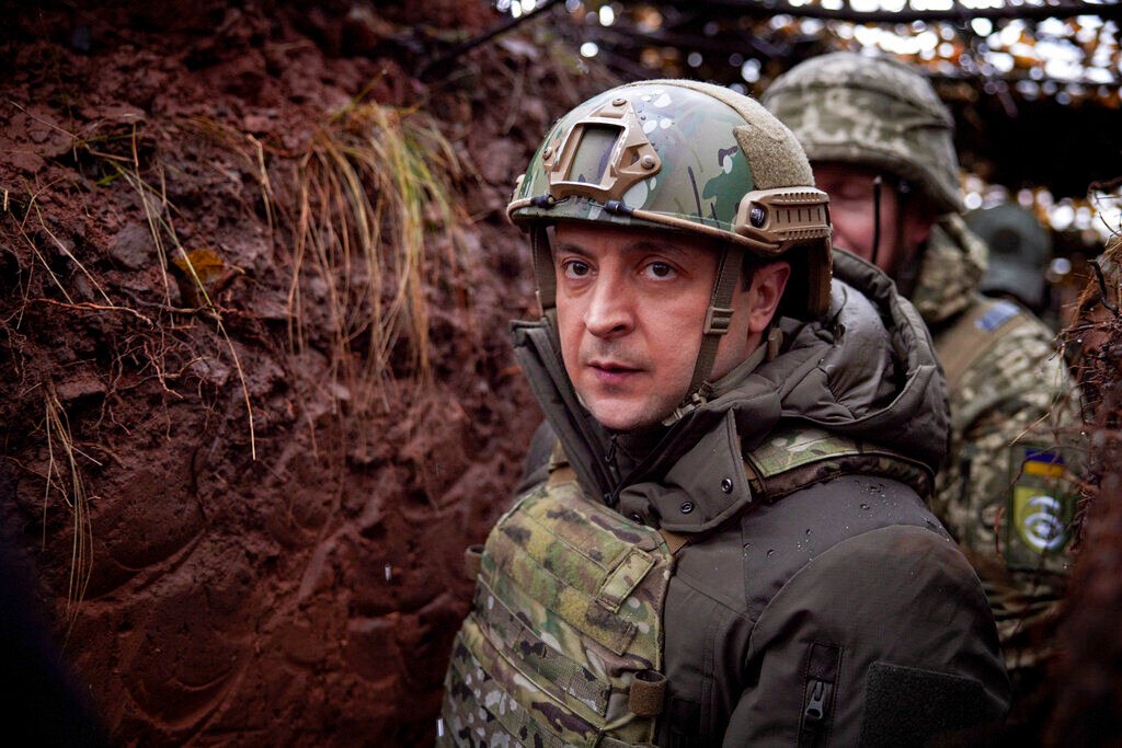 <p>FILE - Ukrainian President Volodymyr Zelenskyy, walks under a camouflage net in a trench as he visits the war-hit Donetsk region, eastern Ukraine, Dec. 6, 2021. </p>