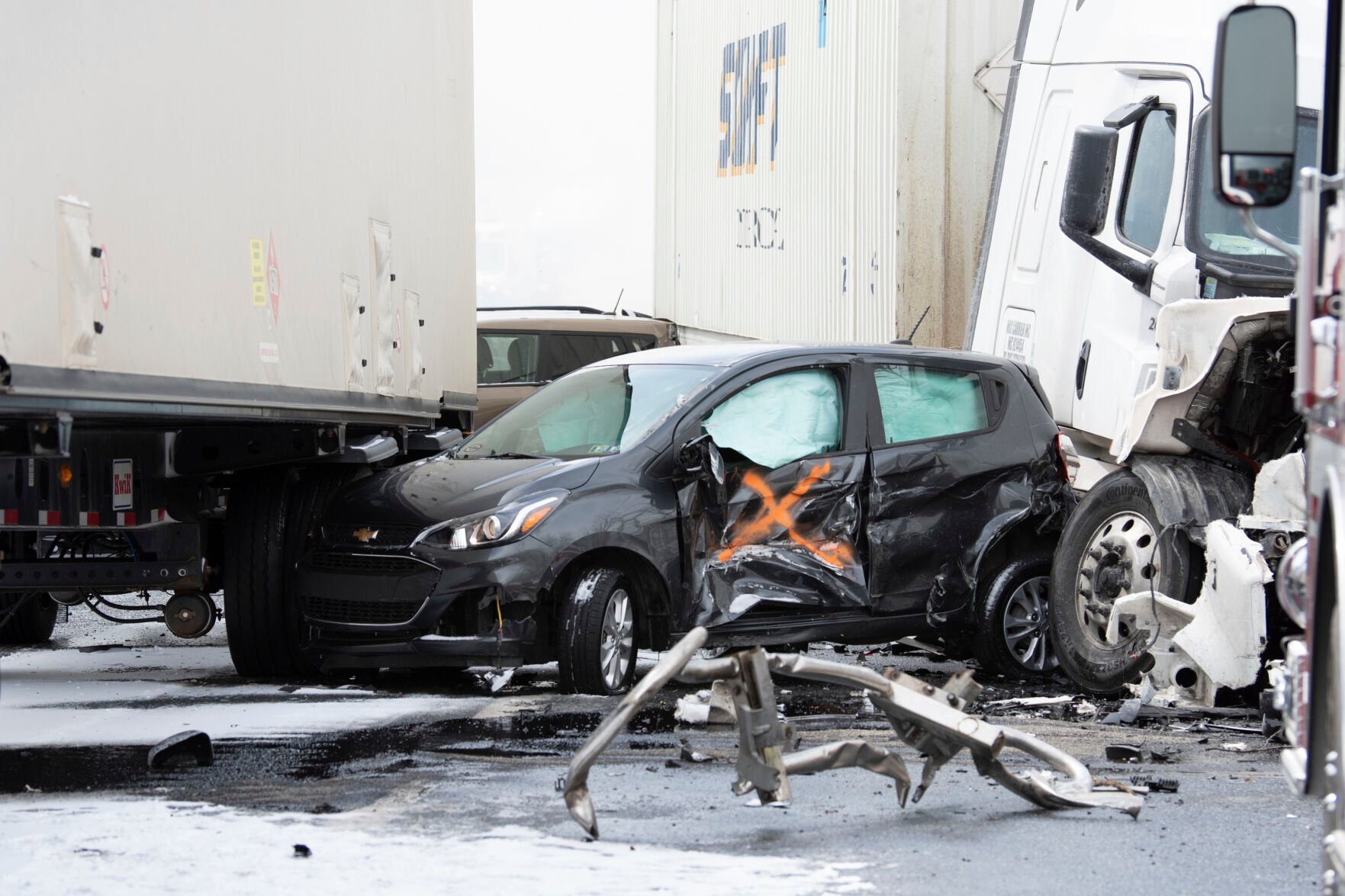 <p>A small car is crushed between tractor trailers following a multi-vehicle crash on Interstate 81 North near the Minersville exit in Foster Township, Pa., Monday, March 28, 2022.</p>