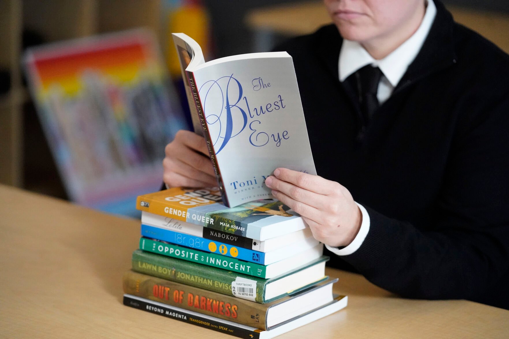 <p>FILE - Amanda Darrow, director of youth, family and education programs at the Utah Pride Center, poses with books, including "The Bluest Eye," by Toni Morrison, that have been the subject of complaints from parents in Salt Lake City on Dec. 16, 2021. The wave of book bannings around the country has reached a level not seen for decades. (AP Photo/Rick Bowmer, File)</p>