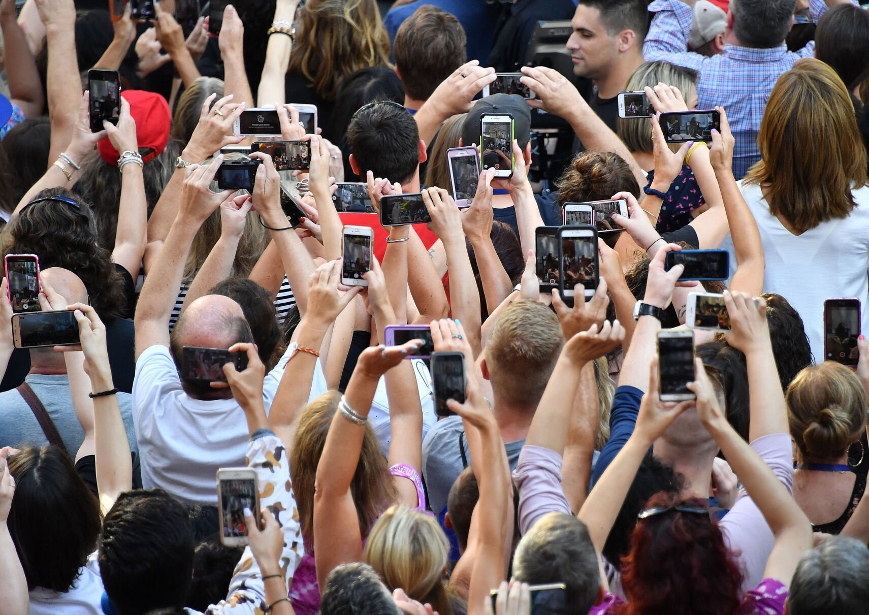 <p>People take photos and videos with their cellphones as Aerosmith performs on NBC's "Today" show at Rockefeller Center on Aug. 15, 2018, in New York.</p>