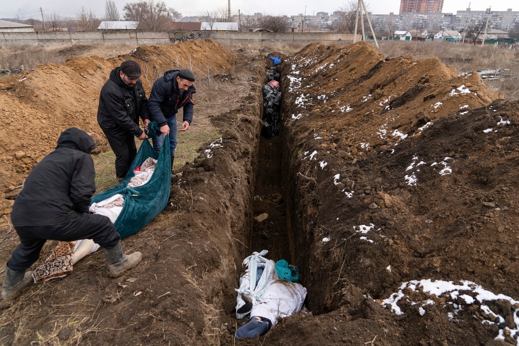 <p>Dead bodies are placed into a mass grave on the outskirts of Mariupol, Ukraine, Wednesday, March 9, 2022, as people cannot bury their dead because of heavy shelling by Russian forces. </p>