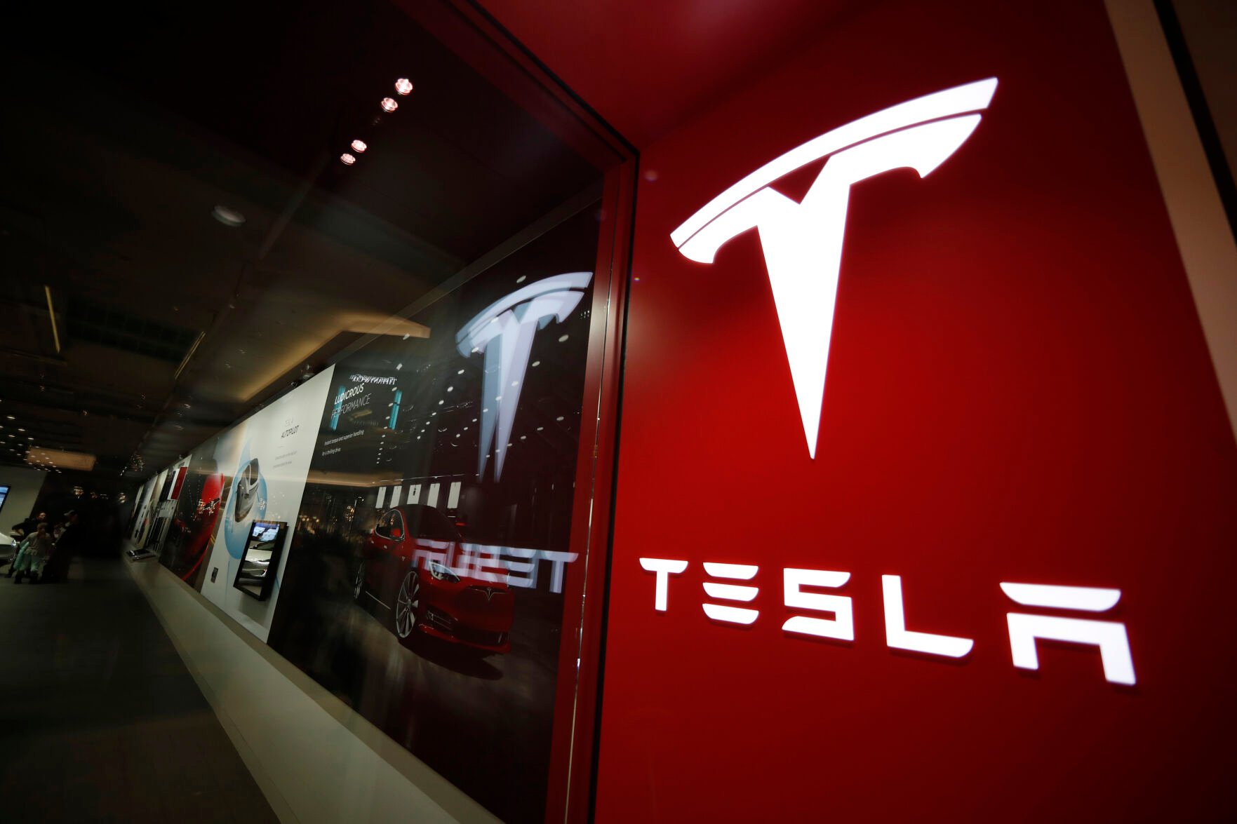 <p>FILE - A sign bearing the company logo outside a Tesla store in Cherry Creek Mall in Denver, Feb. 9, 2019. Tesla is looking to split its stock so that the electric vehicle maker can pay a dividend to its shareholders. The company said in a regulatory filing that it plans to make a request at its upcoming annual shareholders meeting to increase its number of authorized shares so that it can split the stock in the form of a dividend.</p>