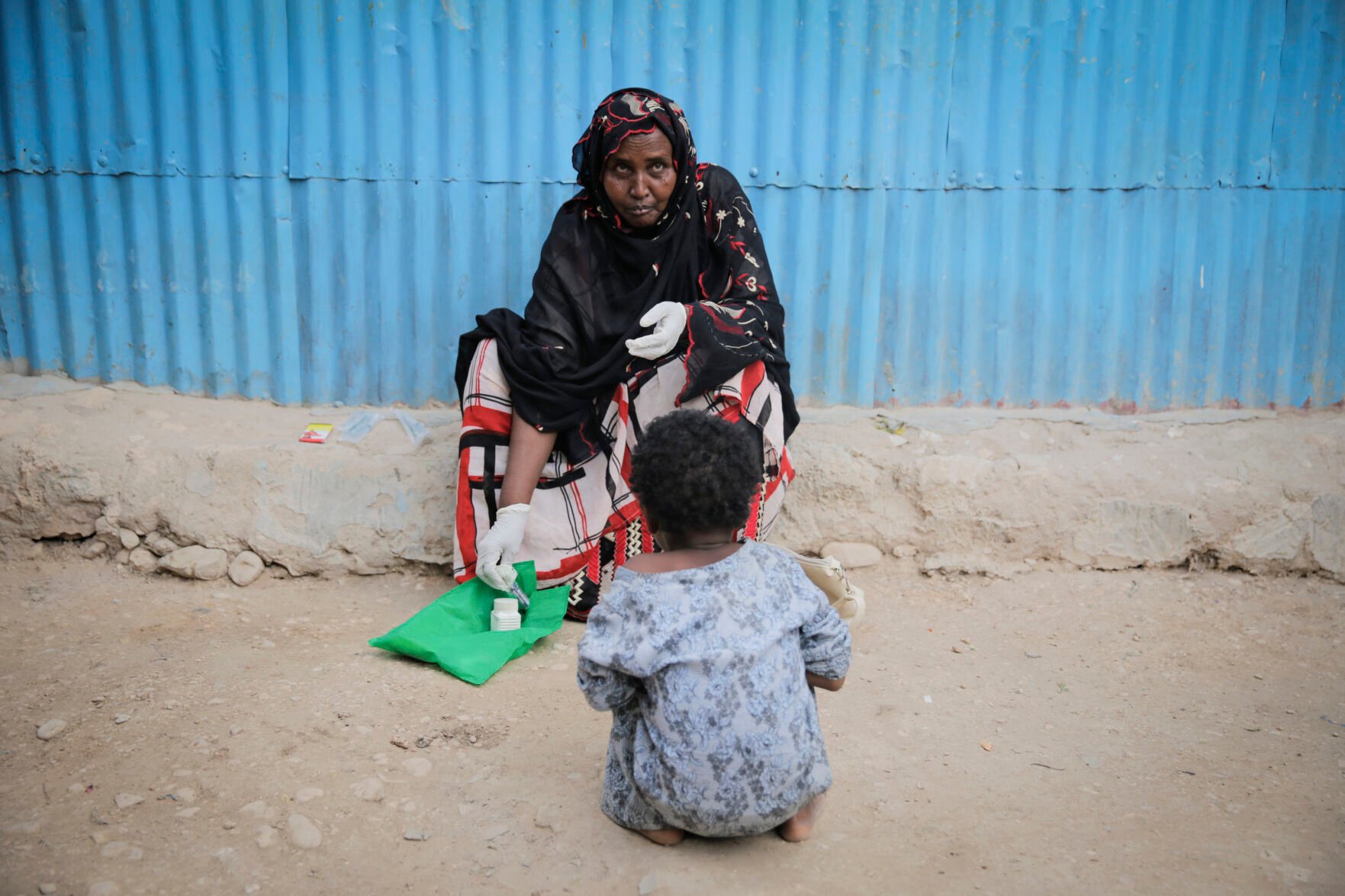<p>Safia Ibrahim demonstrates for the camera the tools and techniques she uses to perform female genital mutilation (FGM), which she learned at the age of 15 and has been practising for 35 years, as her neighbours daughter looks on in the courtyard of her home in Hargeisa, Somaliland, a semi-autonomous breakaway region of Somalia, on Feb. 7, 2022. Officials and health workers say cases of female genital mutilation increased during the pandemic in parts of Africa and particularly in Somaliland where 98 percent of girls aged 5 to 11 undergo the procedure. (AP Photo/Brian Inganga)</p>