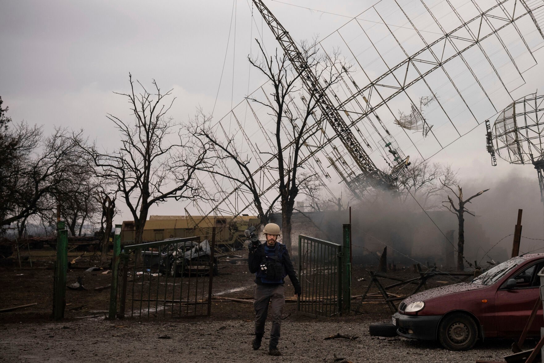 <p>Associated Press videographer Mstyslav Chernov walks amid smoke rising from an air defense base in the aftermath of a Russian strike in Mariupol, Ukraine, Thursday, Feb. 24, 2022. </p>