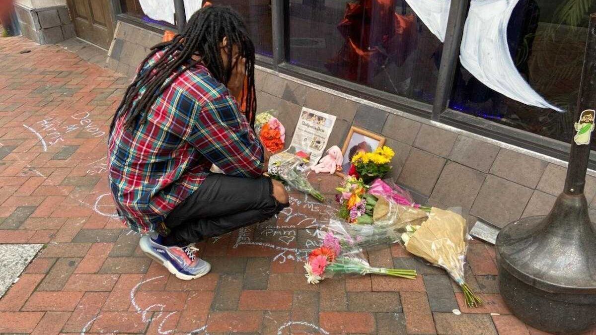 <p>Tyree Wise, 26, crouches down Sunday, March 20, 2022, at a memorial for Sierra Jenkins and others shot outside Chichos Pizza Backstage. Wise ran track in high school with Jenkins, who was shot and killed early Saturday while leaving the bar. "When she set her mind on something she did it," Wise said. "We were all so proud of her and all she accomplished."</p>
