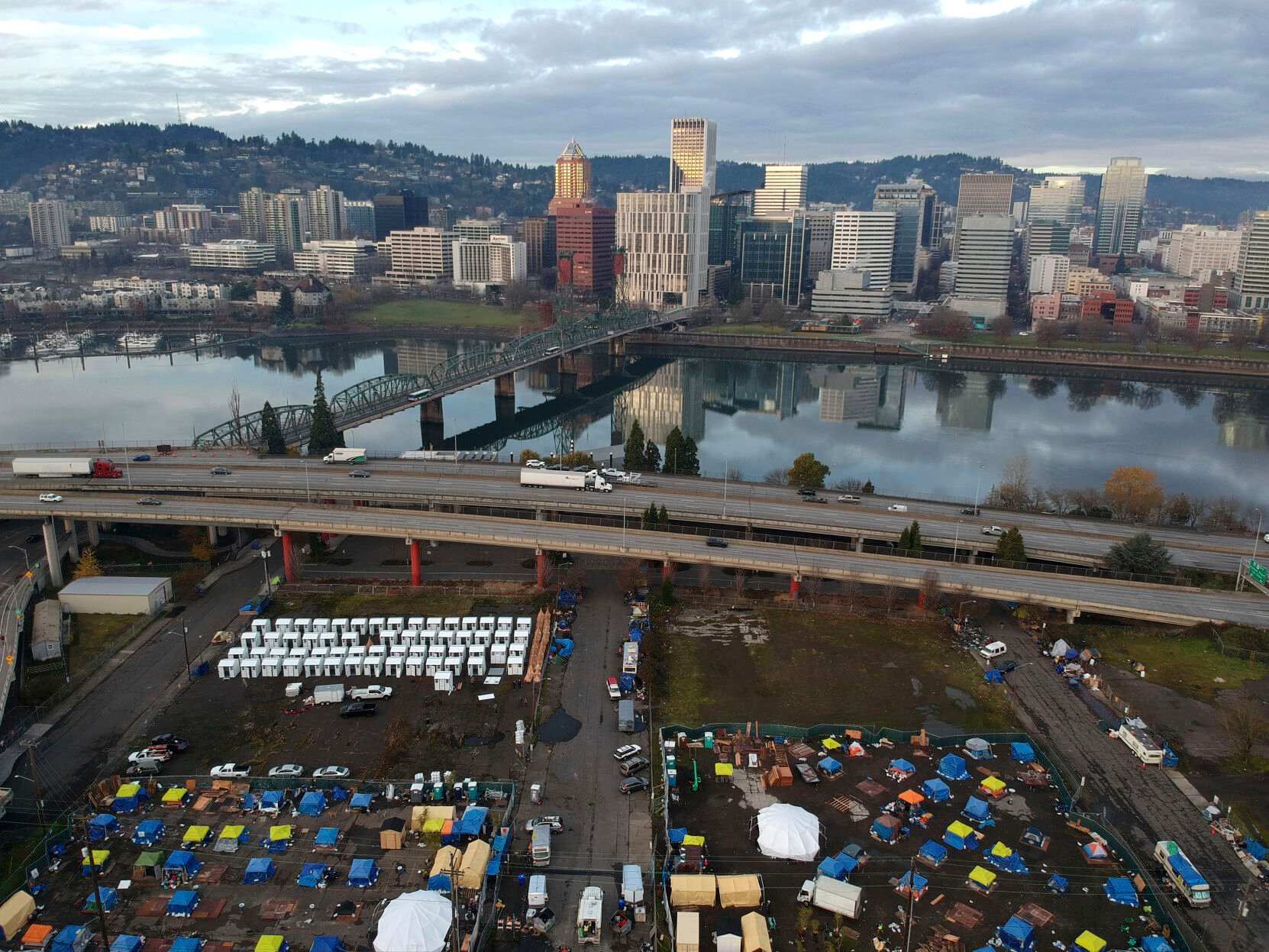 <p>FILE - In this aerial photo taken with a drone, tents housing people experiencing homelessness are set up on a vacant parking lot in Portland, Ore., on Dec. 8, 2020. </p>
