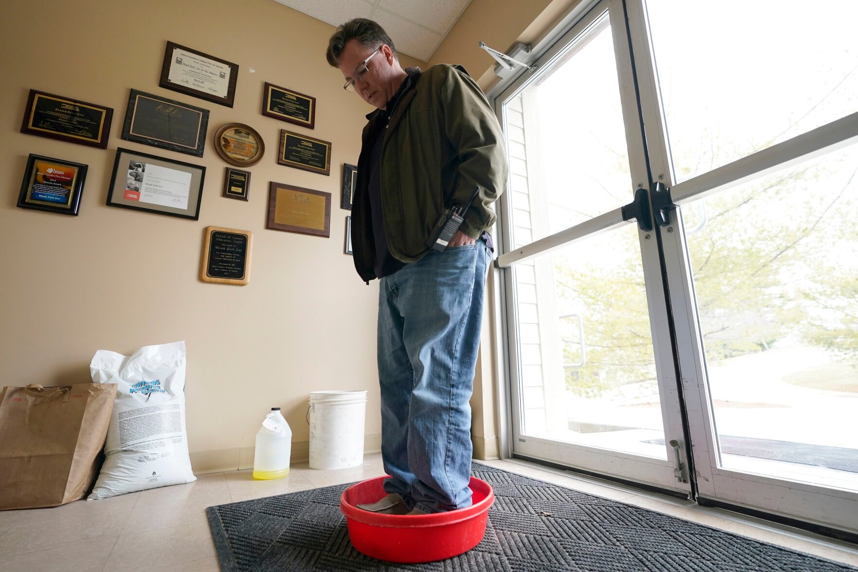 <p>Chief Marketing Officer Ryan Bickel walks through a shoe disinfectant as he enters a building at the Blank Park Zoo, Tuesday, April 5, 2022, in Des Moines, Iowa. </p>