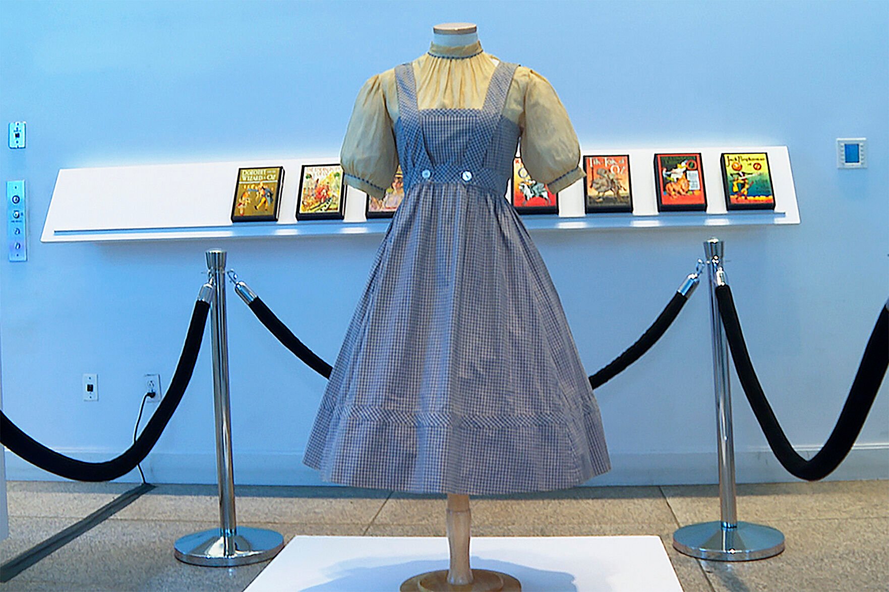 <p>A blue and white checked gingham dress, worn by Judy Garland in the "Wizard of Oz," hangs on display, Monday, April 25, 2022, at Bonhams in New York. </p>