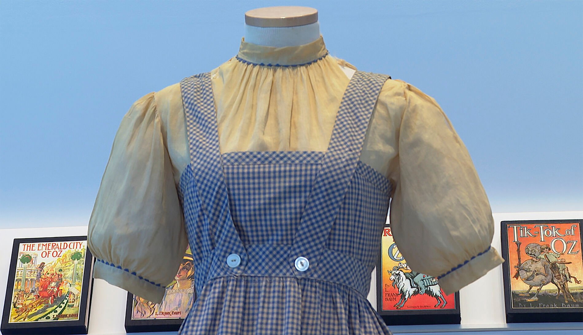 <p>A blue and white checked gingham dress, worn by Judy Garland in the "Wizard of Oz," hangs on display, Monday, April 25, 2022, at Bonhams in New York. </p>