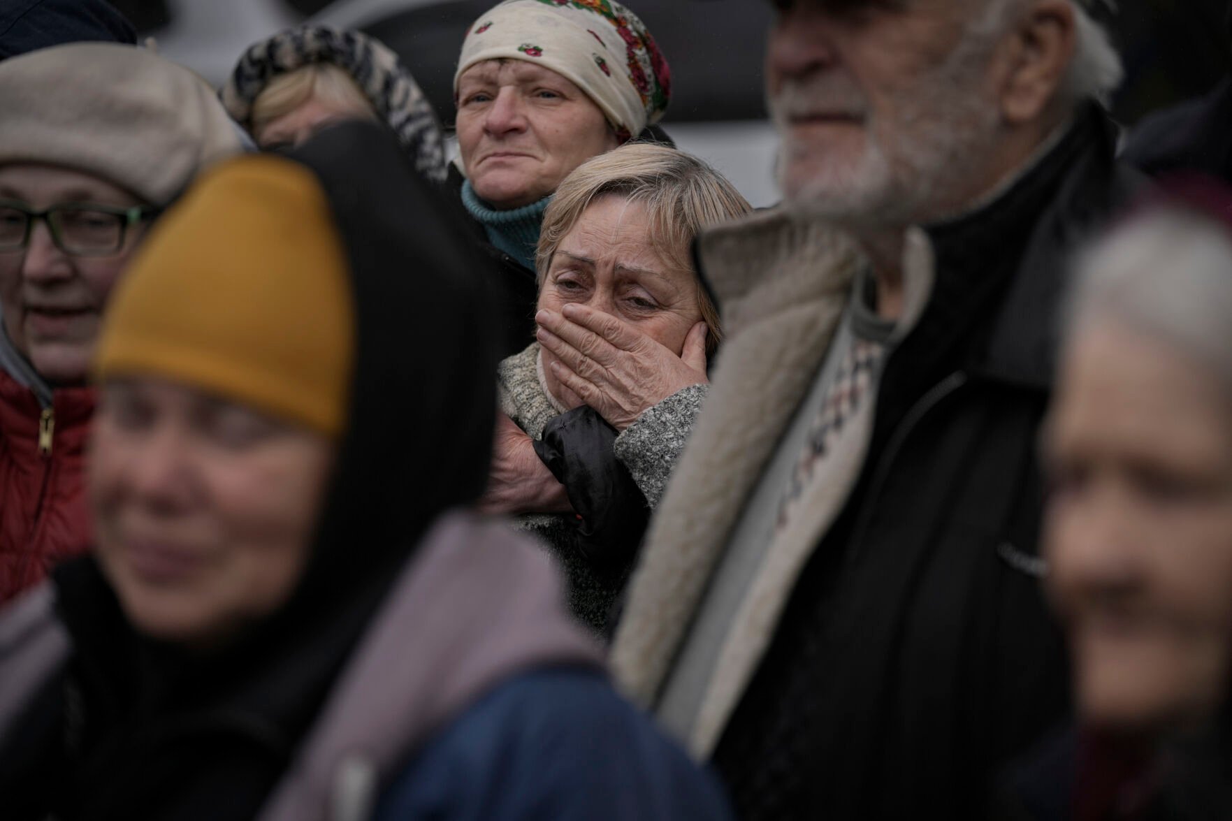 <p>FILE - A woman cries as residents listen to a Ukrainian serviceman speaking after a convoy of military and aid vehicles arrived in the formerly Russian-occupied Kyiv suburb of Bucha, Ukraine, April 2, 2022. (AP Photo/Vadim Ghirda)</p>