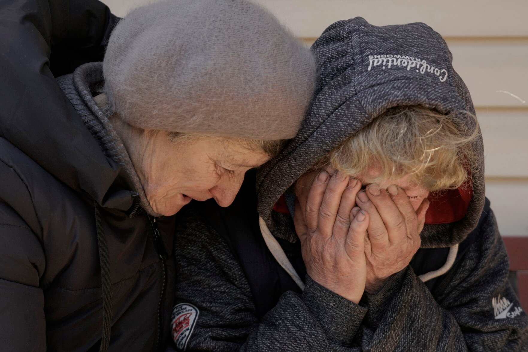 <p>FILE - A neighbor comforts Natalya, whose husband and nephew were killed by Russian forces, as she cries in her garden in Bucha, Ukraine, Monday, April 4, 2022. (AP Photo/Vadim Ghirda, File)</p>