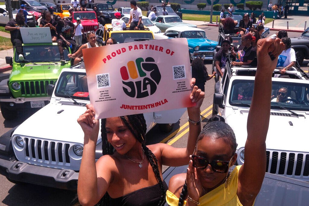 <p>Jasmine Kingi, left, 26, and Robin Renee Green, 26, both from Los Angeles, celebrate as they take part in a car parade to mark Juneteenth on Saturday, June 19, 2021, in Inglewood, Calif. </p>