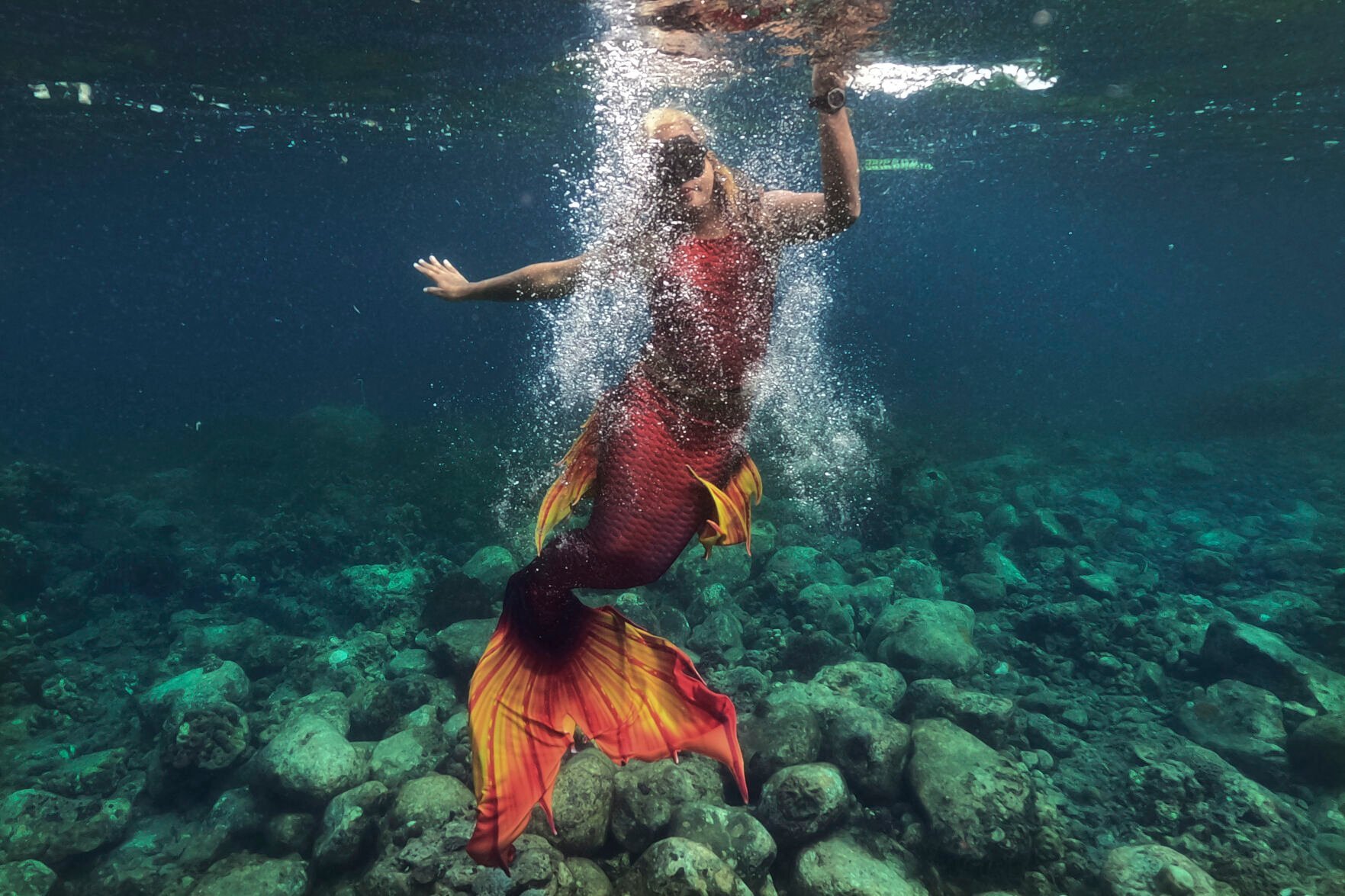<p>Queen Pangke Tabora swims in her mermaid suit while she conducts a mermaiding class in front of the Ocean Camp in Mabini, Batangas province, Philippines on Sunday, May 22, 2022. “The world outside is really noisy and you will find peace under water. … It’s a good skill in the real world, especially during the pandemic.” </p>