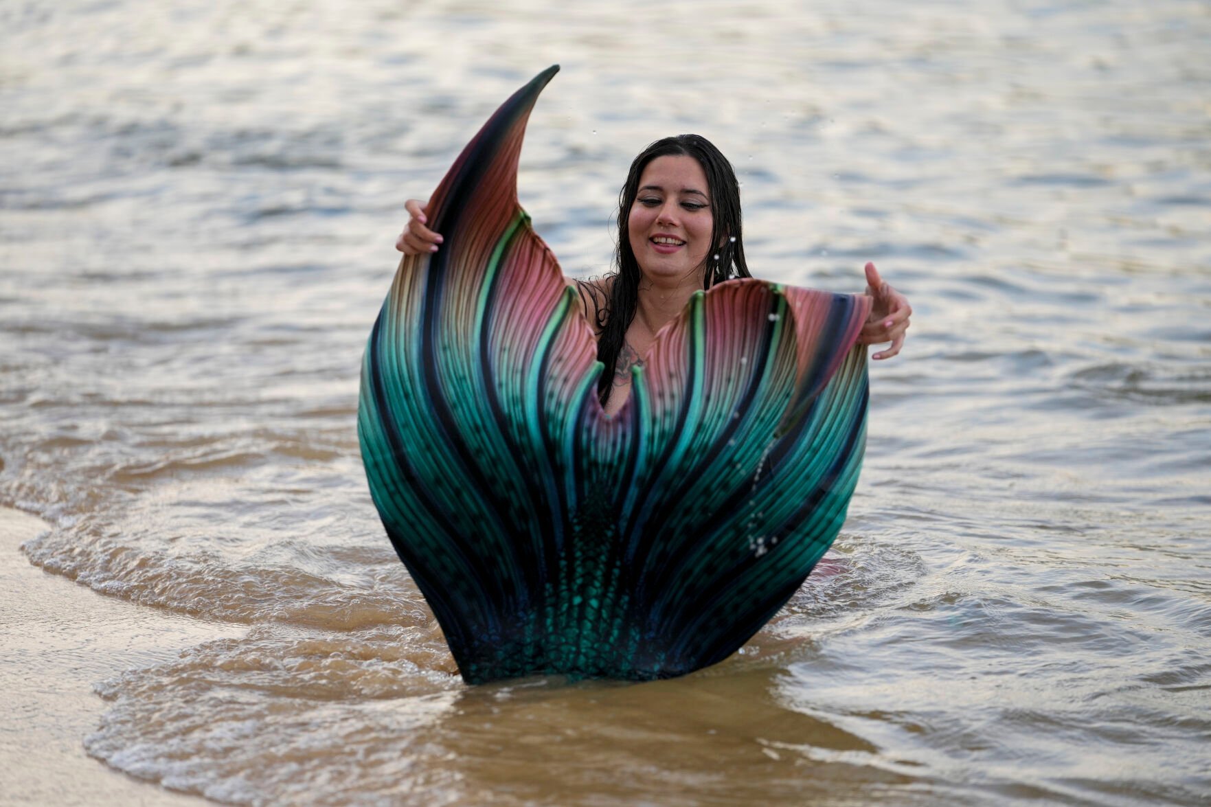 <p>Lauren Metzler, founder of Sydney Mermaids, prepares for a swim at Manly Cove Beach in Sydney, Australia, Thursday, May 26, 2022. Metzler received her advanced mermaid certification this month with a goal of teaching rookie merfolk how to avoid sinking to the seabed. </p>