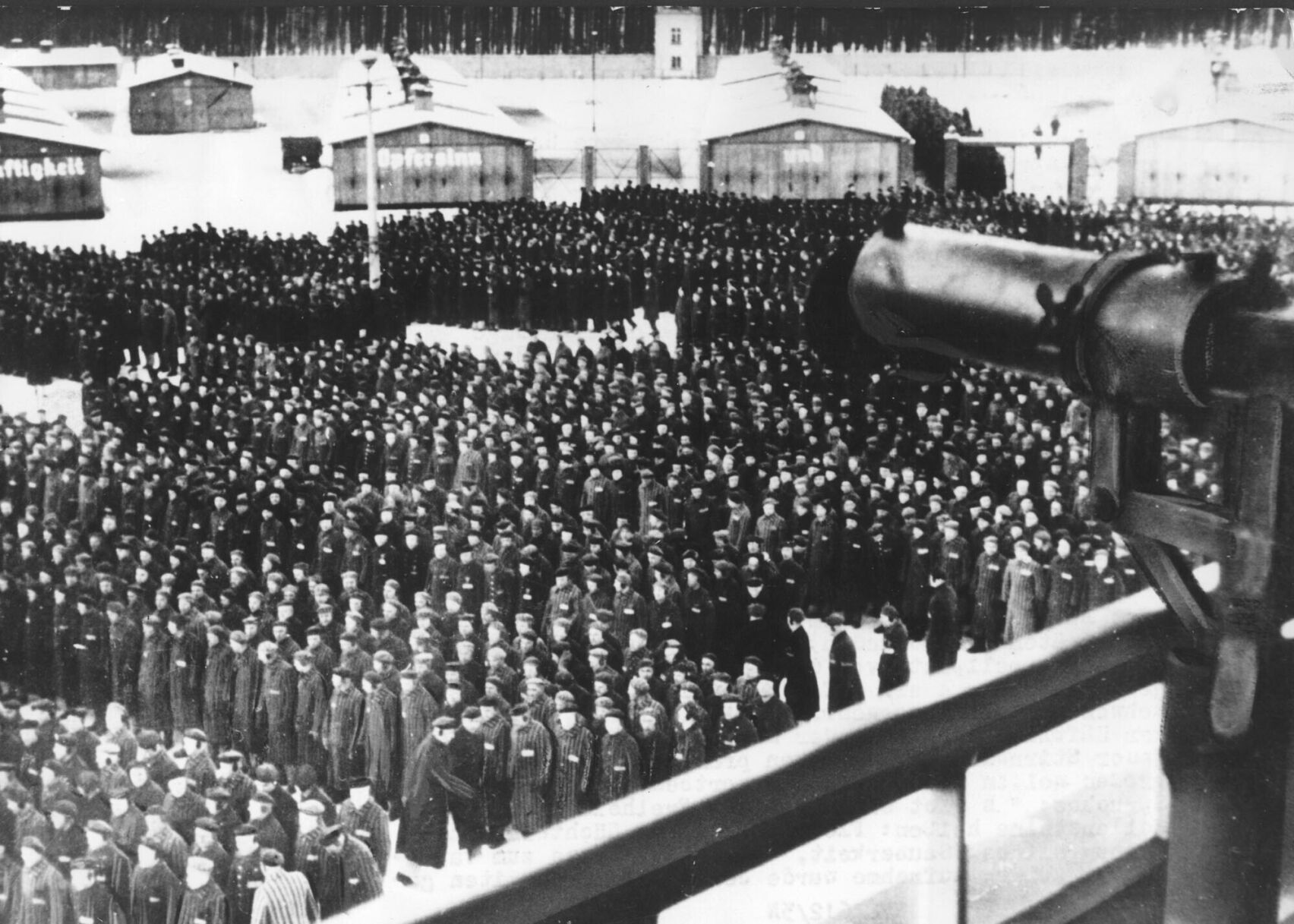 <p>This undated file photo shows a roll call in front of the camp gate of the Nazi concentration camp Sachsenhausen on the outskirts of Berlin, Germany. In the foreground on the tower, a machine gun is pointed at the prisoners.</p>